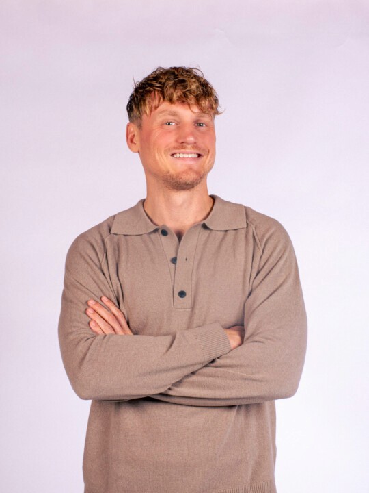 Person dressed in a checkered suit holding hands.