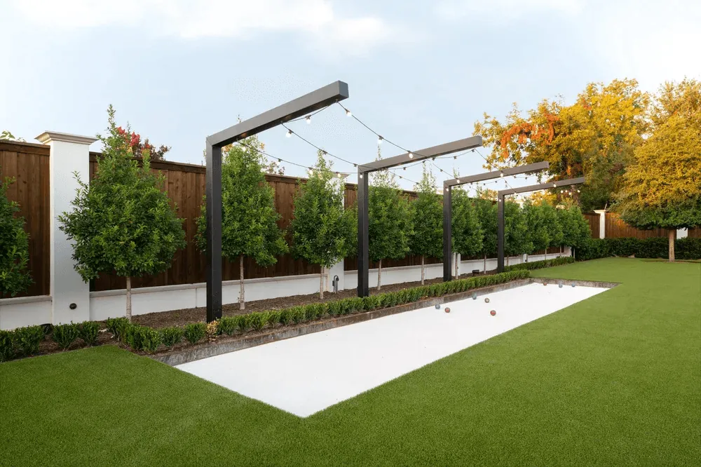 Custom bocce ball court with oyster shell surface and shade structure for Preston Hollow Dallas estate