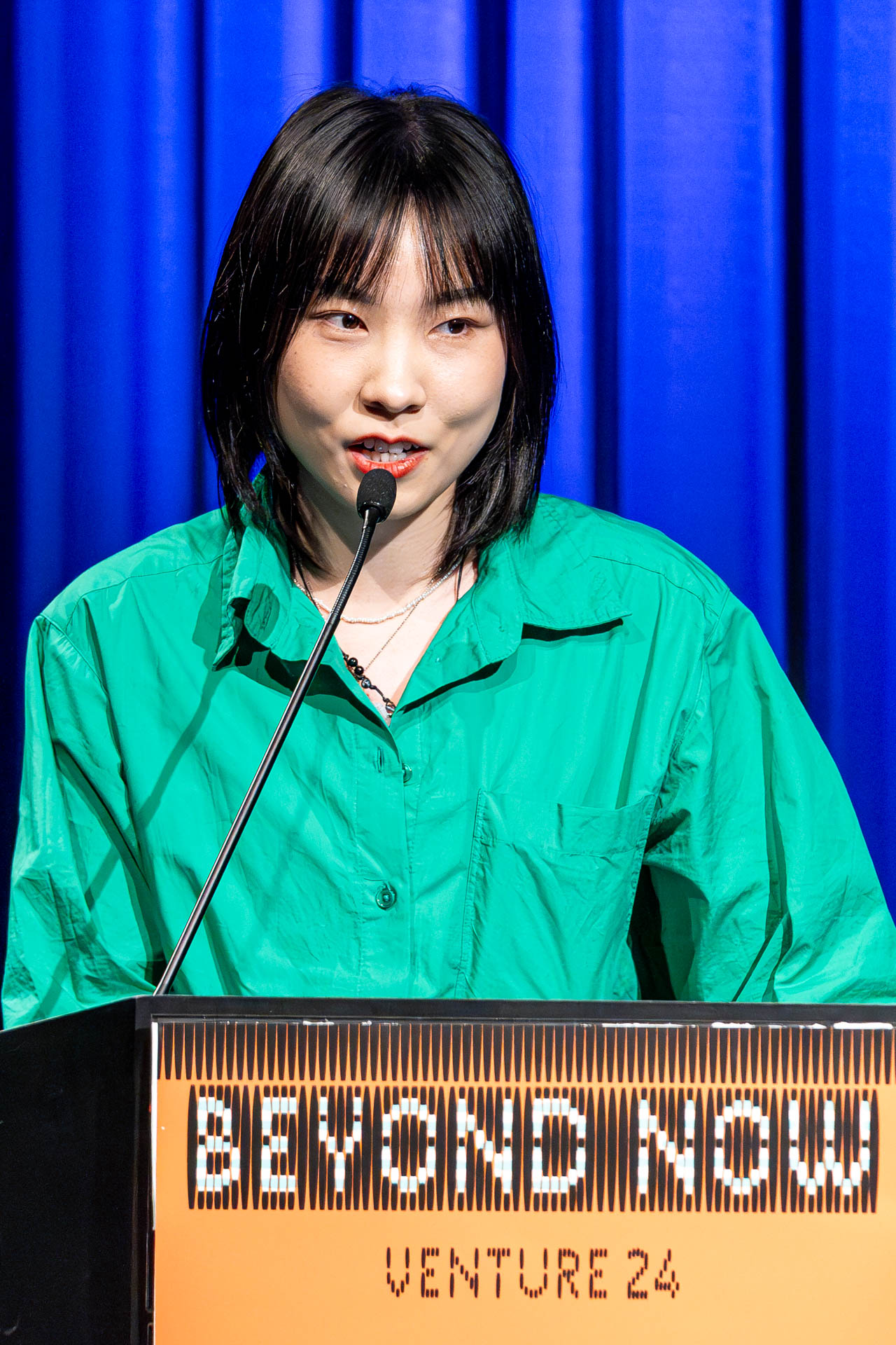 a student at a podium presenting a project in a Theatre