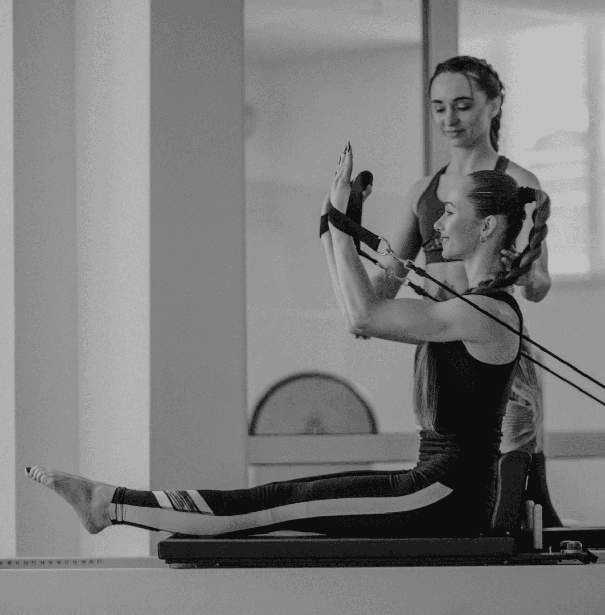 Woman training core muscles with pilates instructor