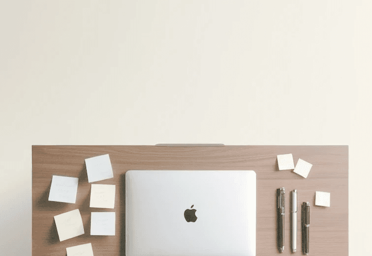 Macbook with sticky notes for project management