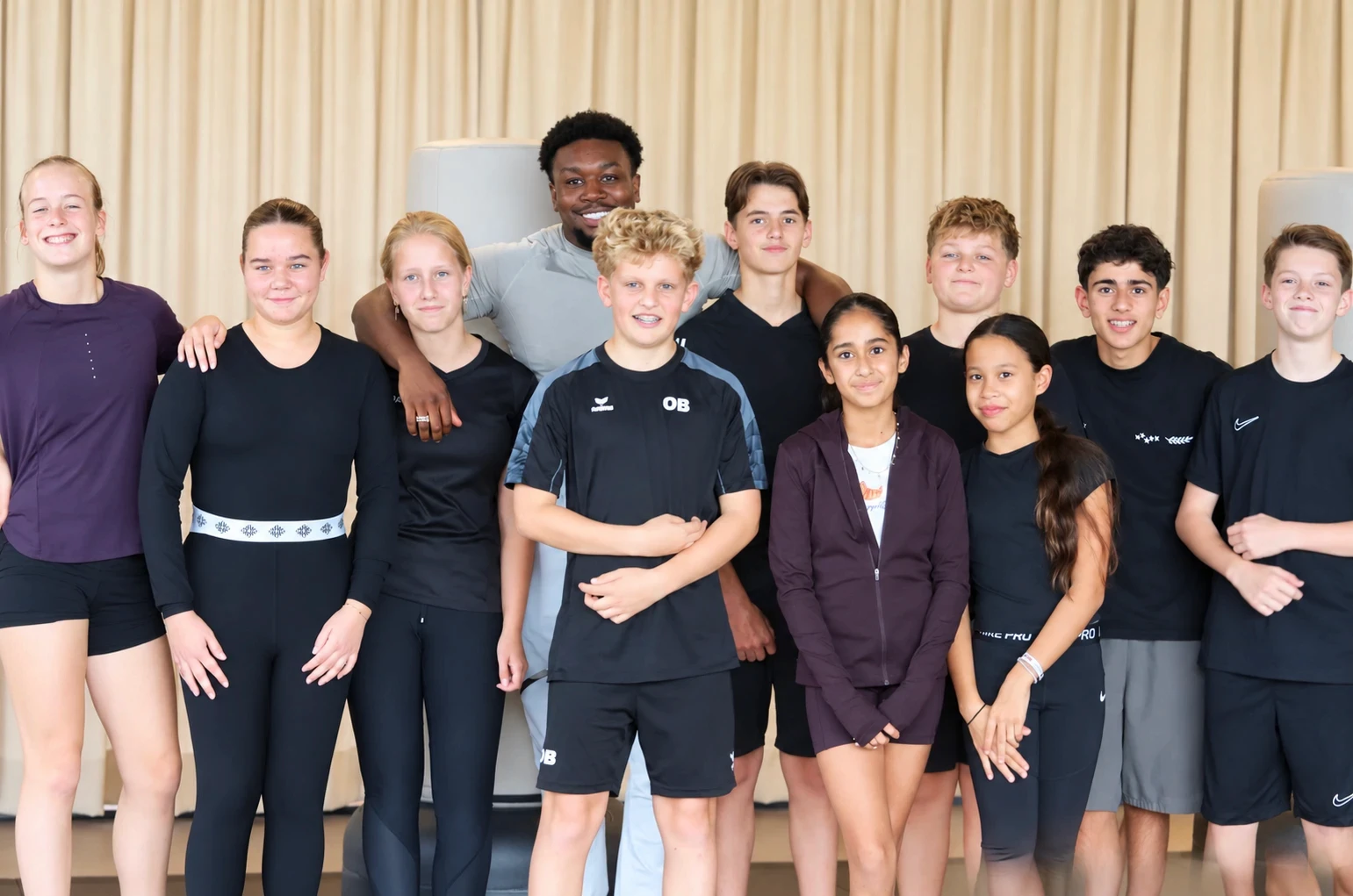 Groep kinderen en tieners met hun boksinstructeur bij Studio Réformé