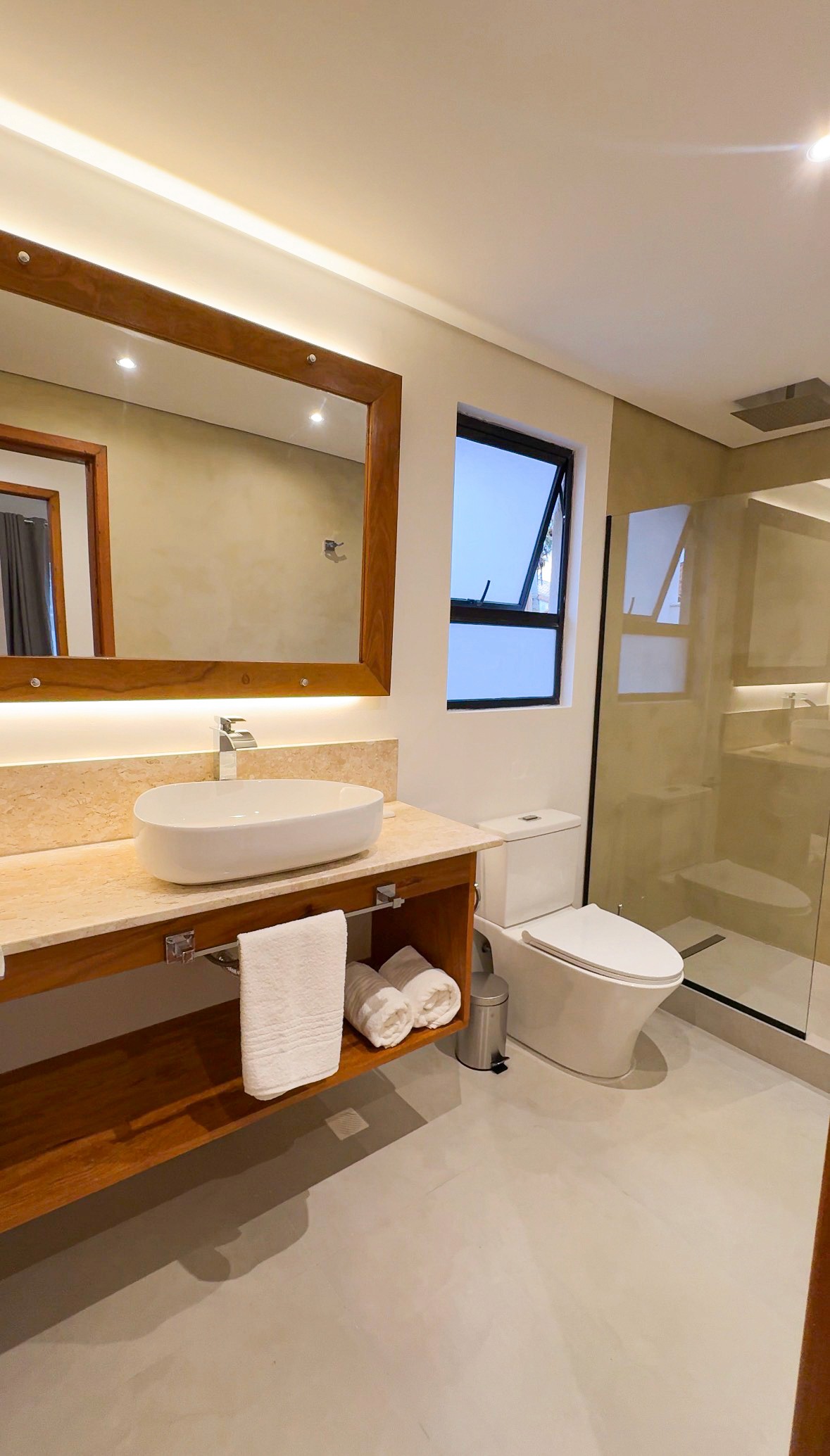 Top-down flat lay of small decor vignette, including coastal magazines on a coffee table, ceramic cups, linen throw on sofa, and part of a jute rug.