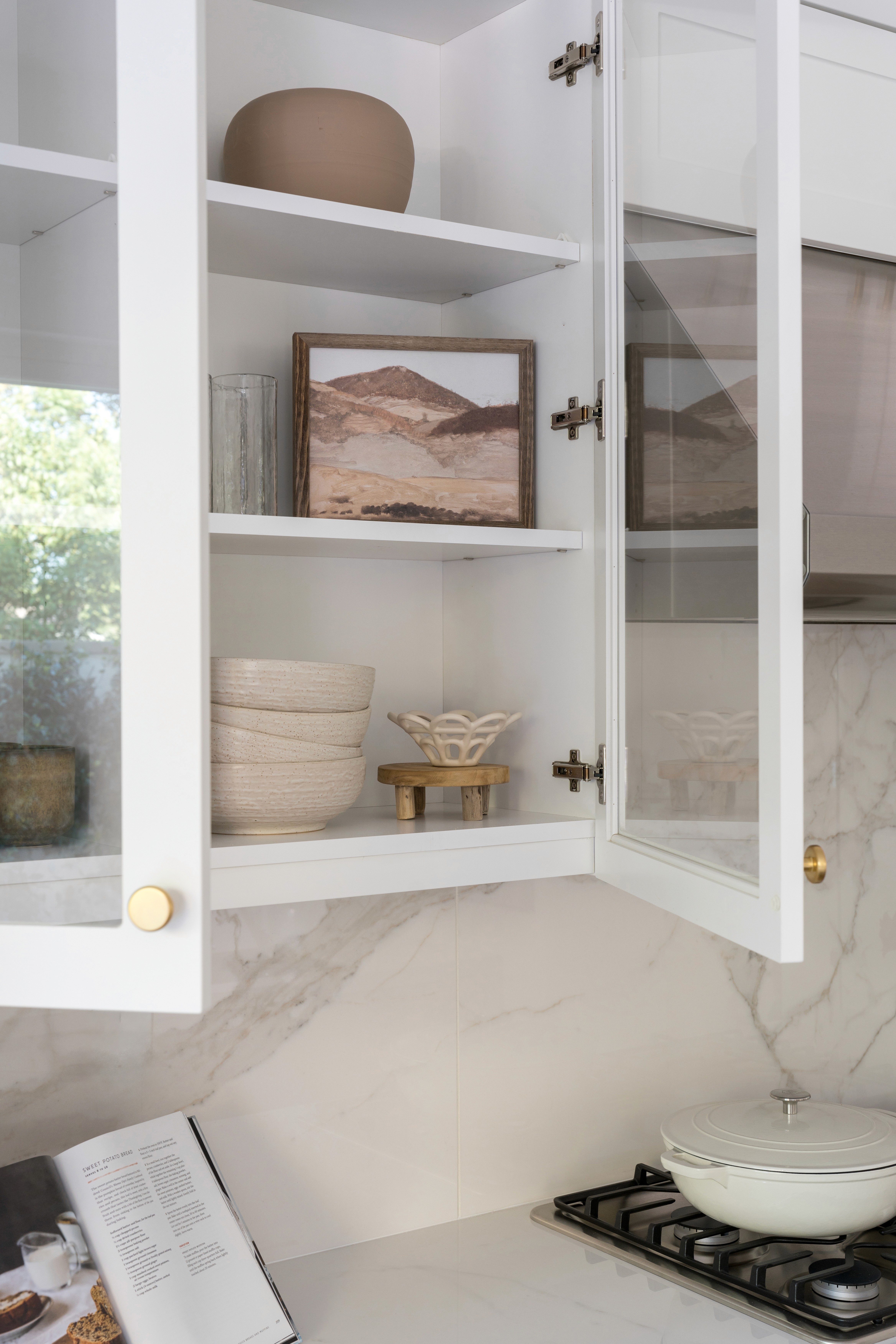 White display cabinet with brass hardware and neutral elements by Jubilee Interiors in Arcadia, California