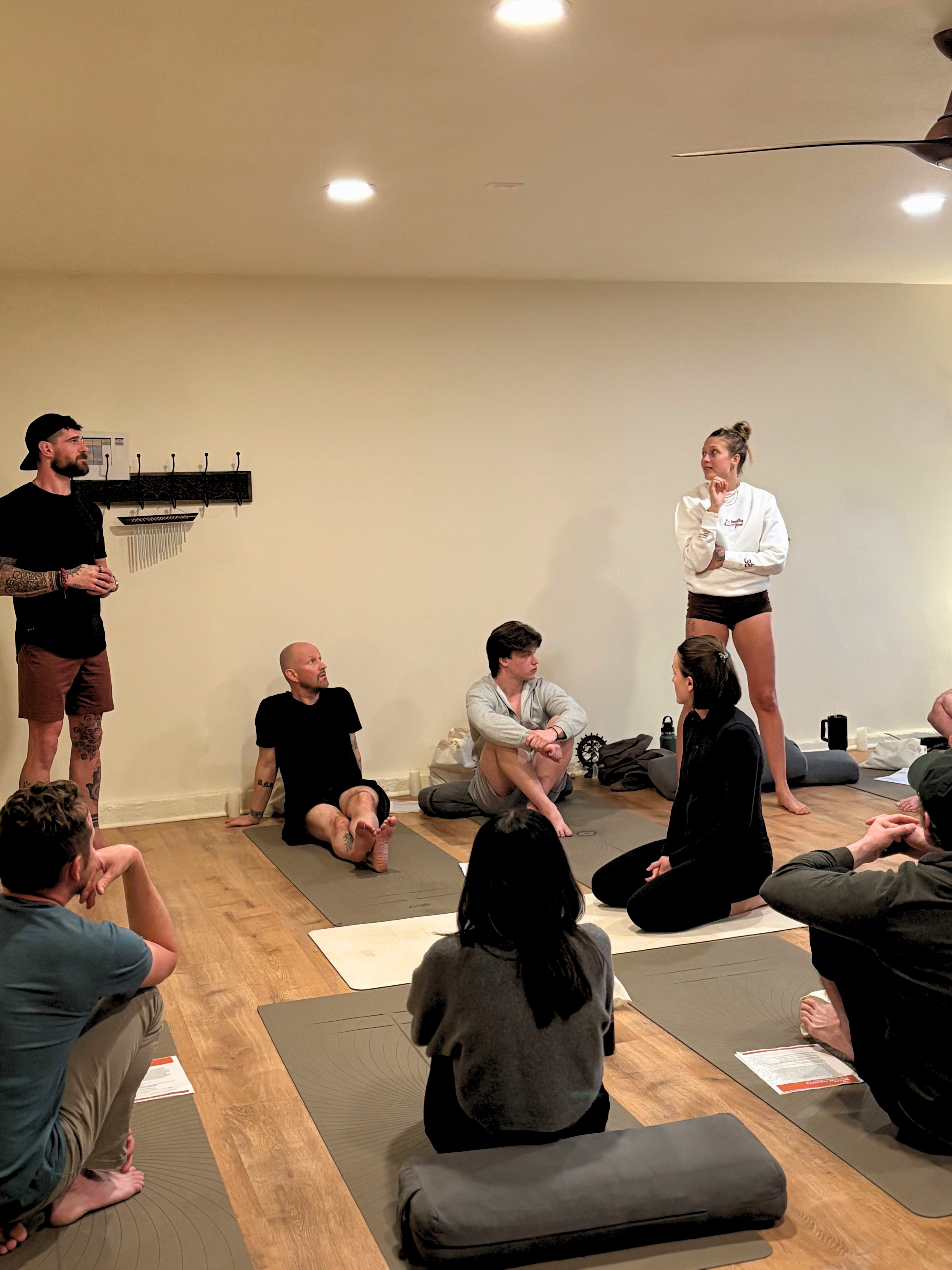 Group yoga retreat participants practicing together in a jungle studio.