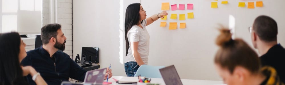 woman leading a meeting with people sat listening