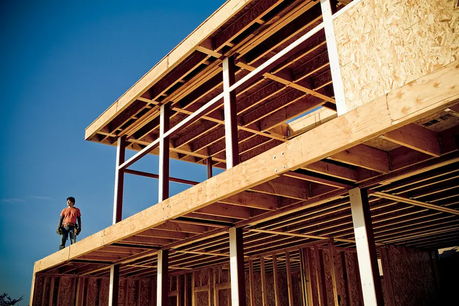 Homebuilder standing on a new construction frame in Central Texas preparing for spray foam insulation installation