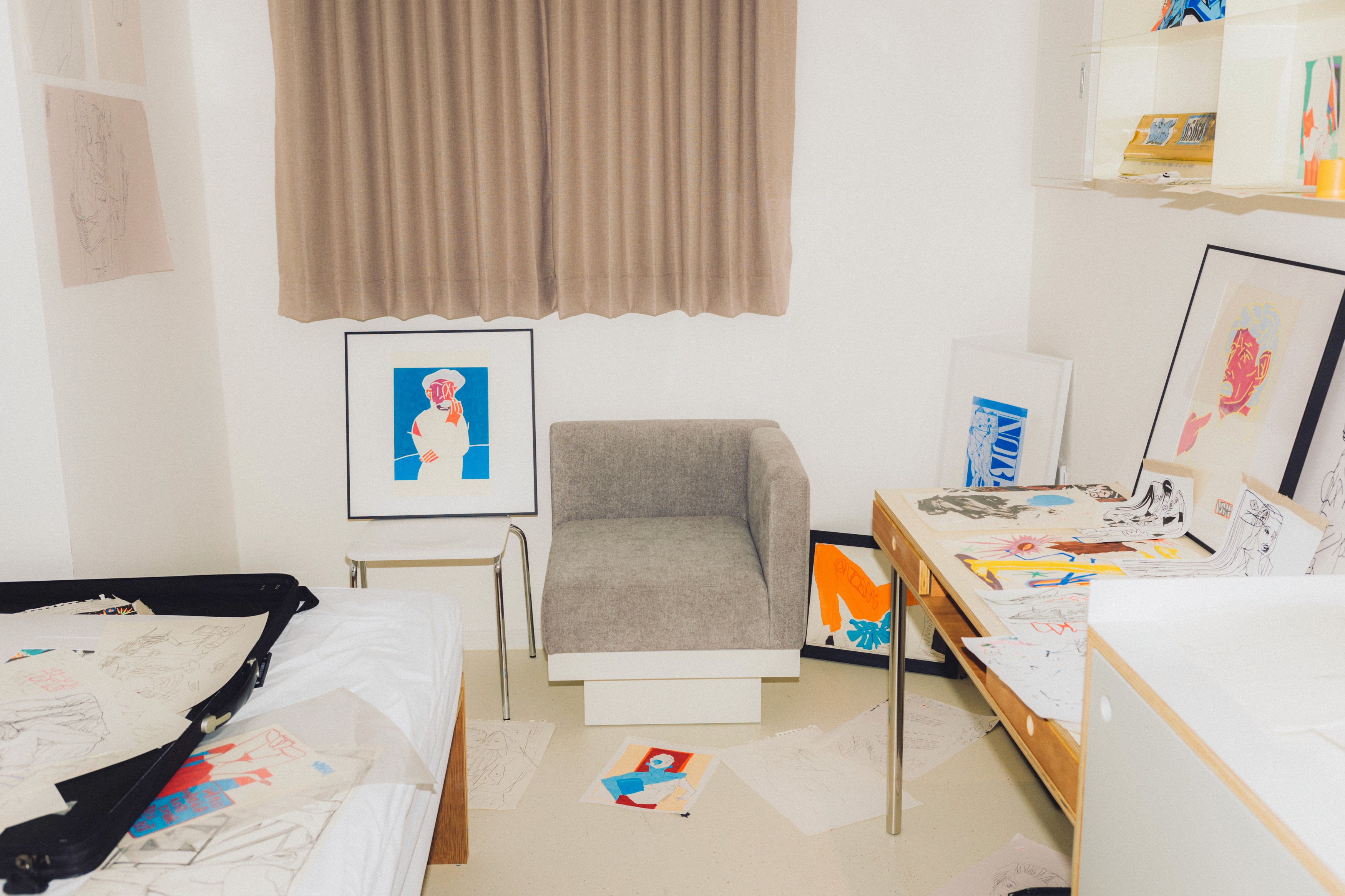A woman with her hair tied back smiles while reading an open book in the library at Mangrove Sinchon.