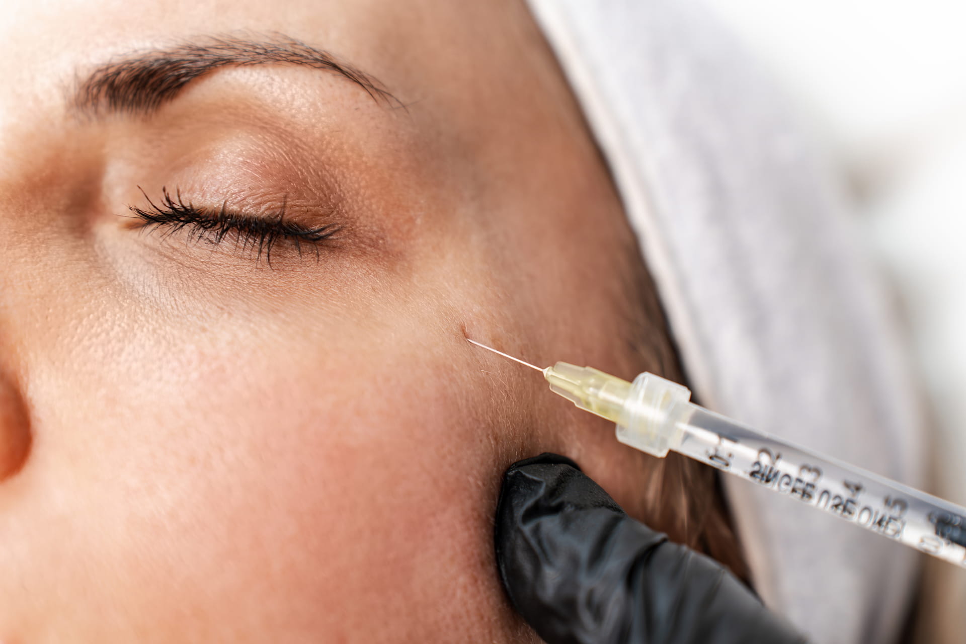 Botox injection near the cheek administered by a gloved practitioner - physician-guided neurotoxin treatment at Avinity Health near Gainey Ranch, Scottsdale.