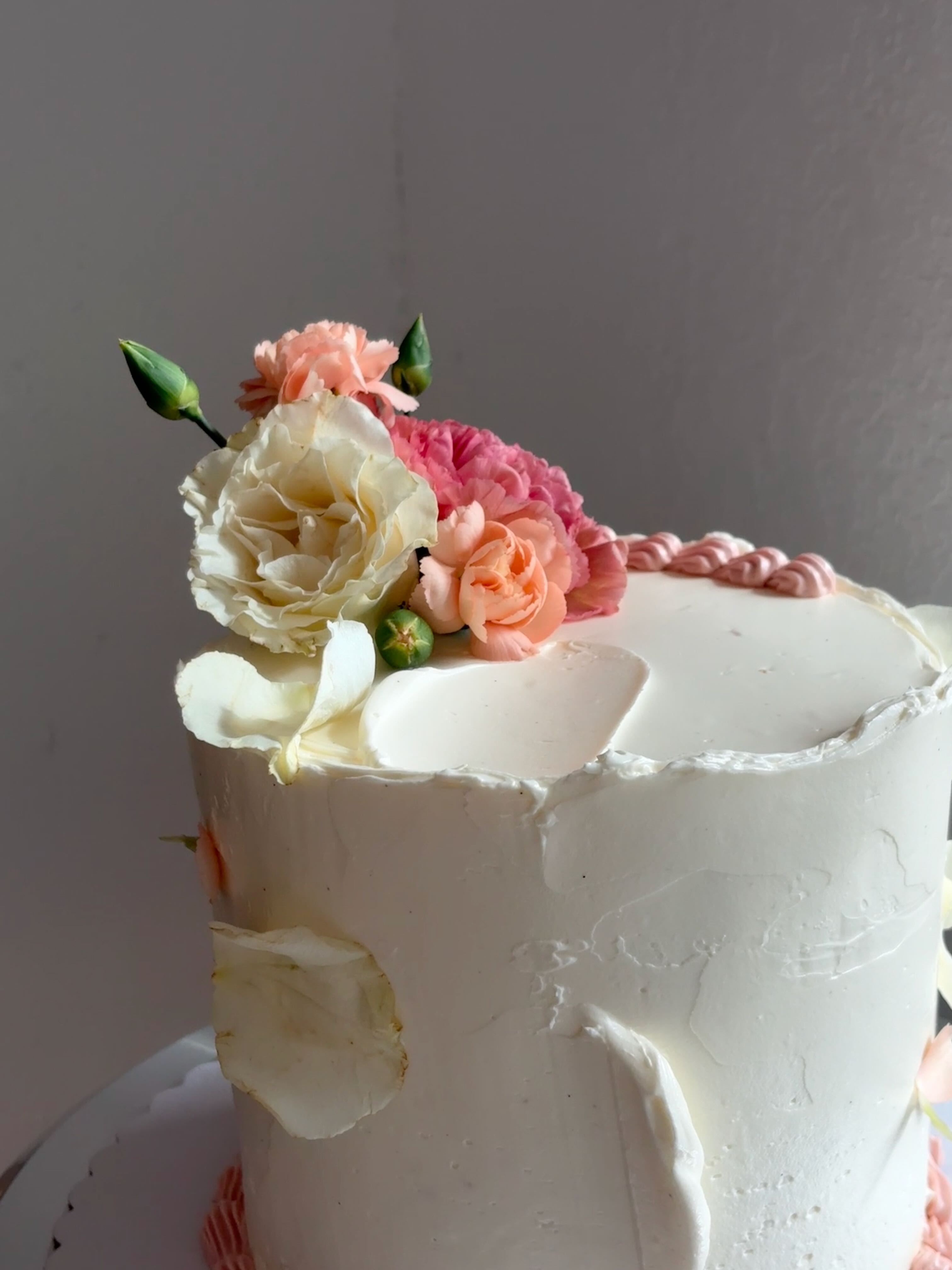 Person wearing a beige apron whisking green matcha tea in a ceramic bowl on a kitchen counter.