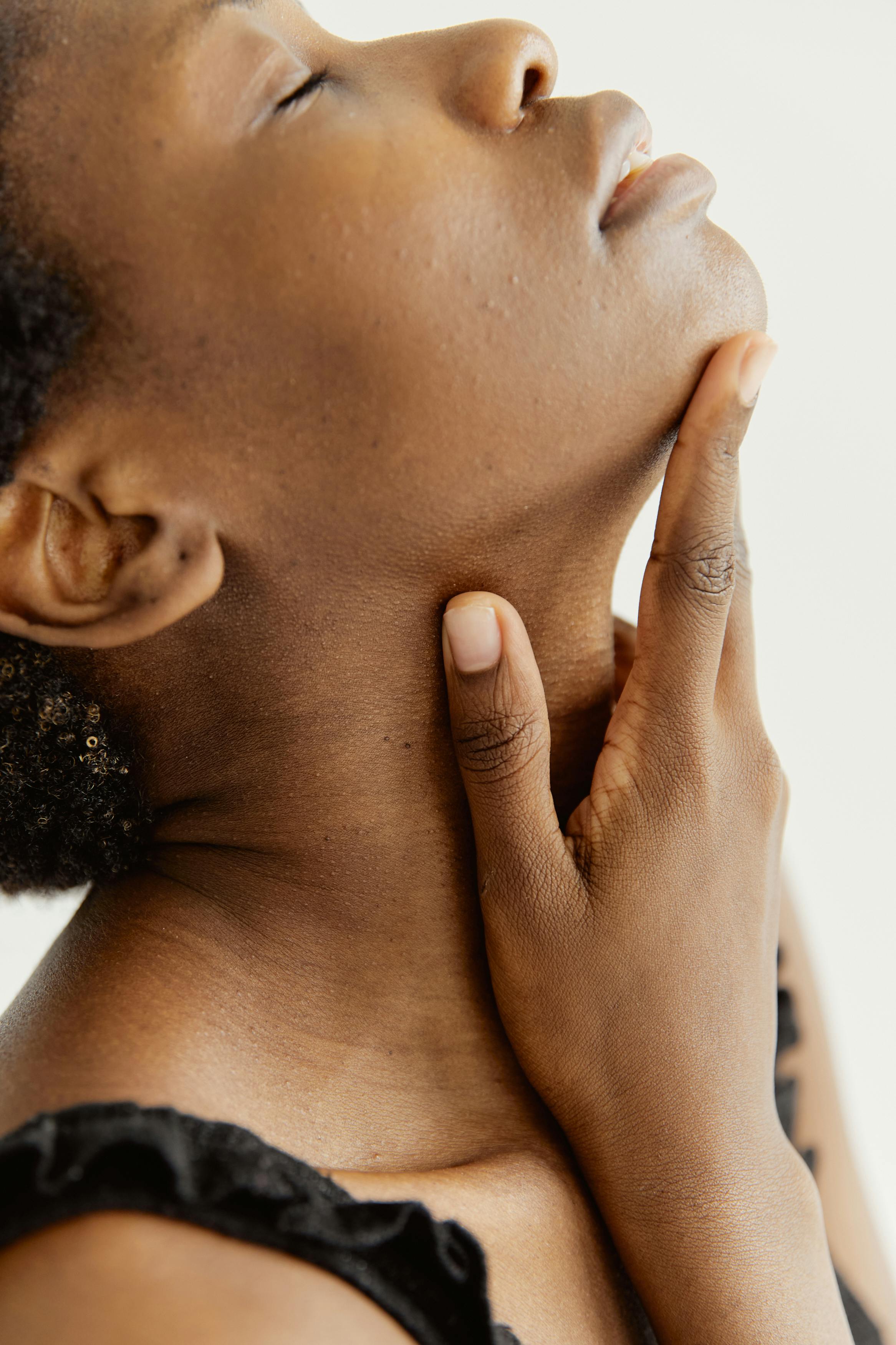 woman softly touching her neck