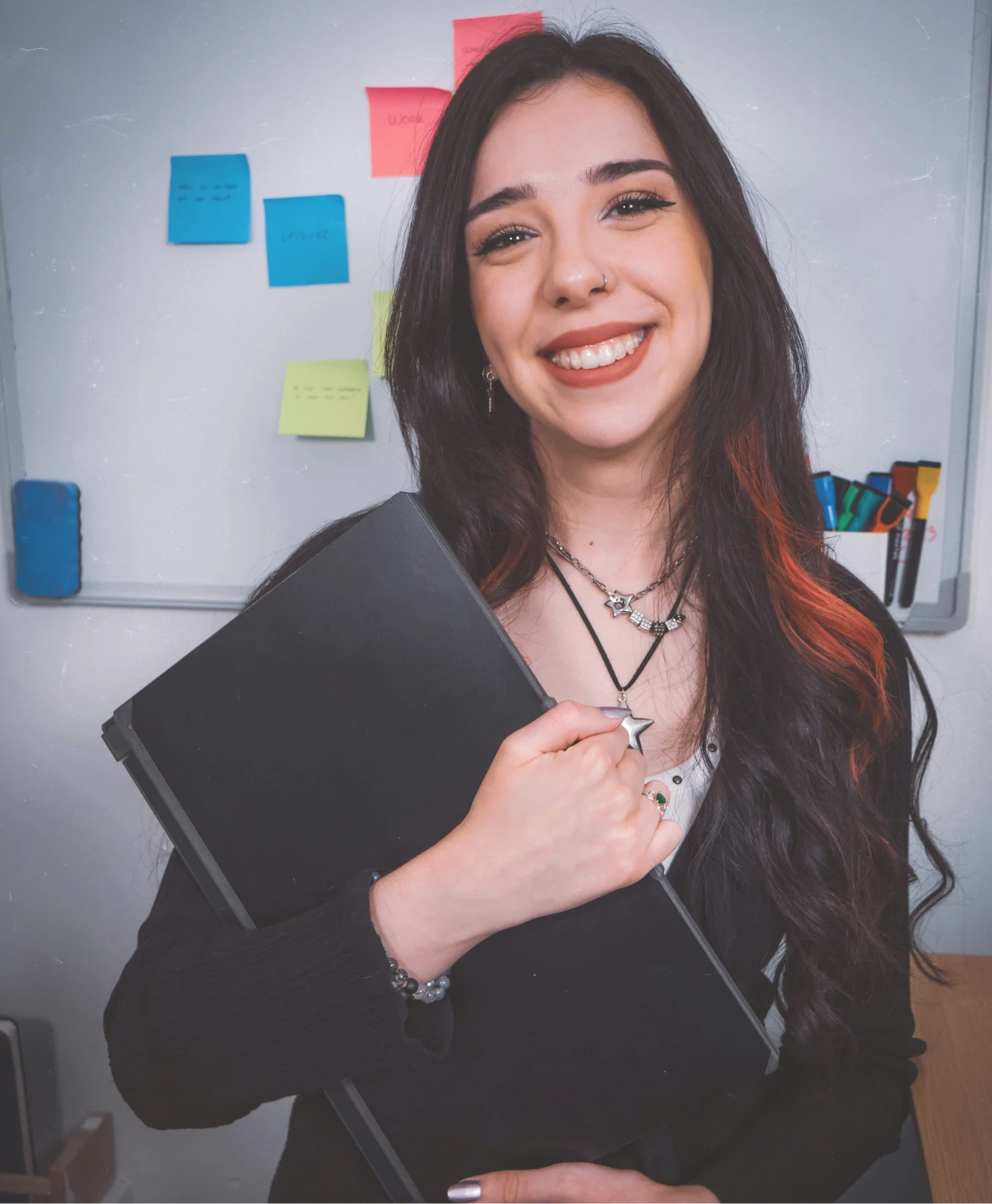 Lorena smiling holding a laptop