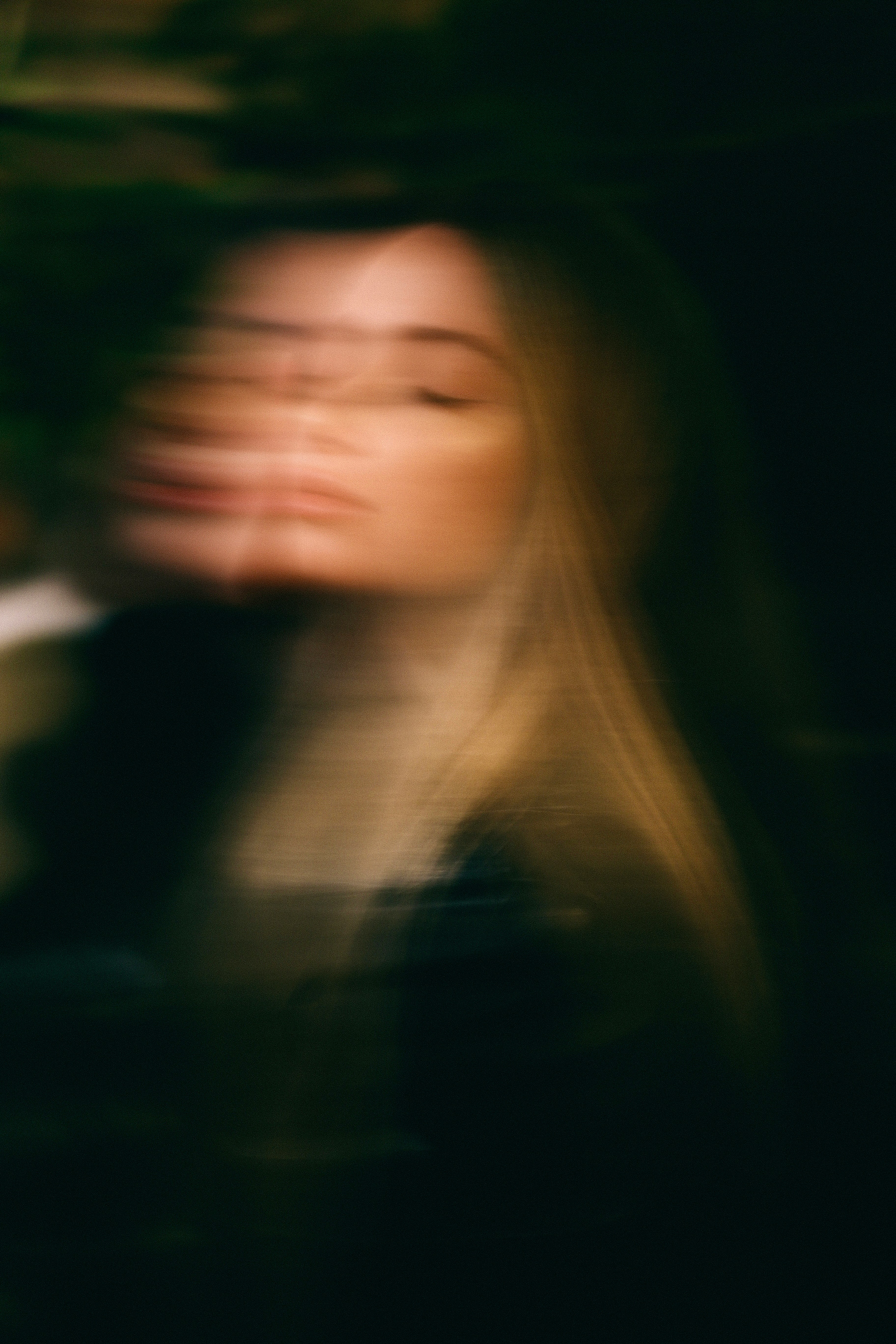 a blurry photo of a woman with her eyes closed