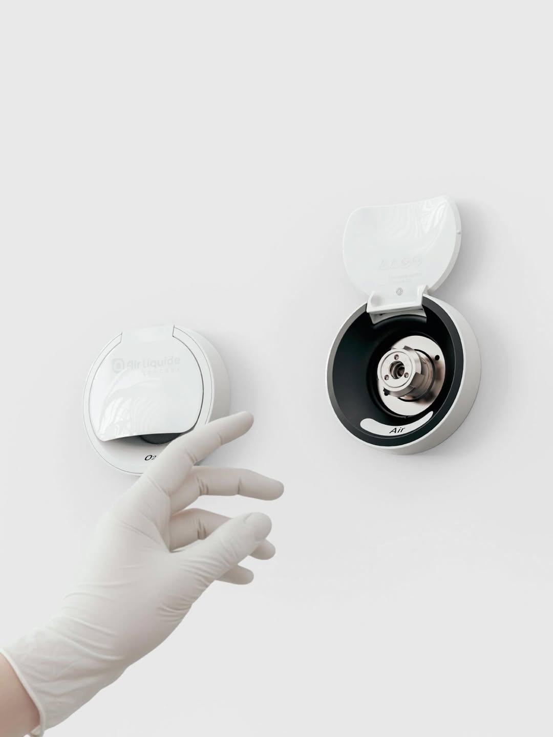 Une main de médecin s’approche délicatement d’une prise murale médicale.