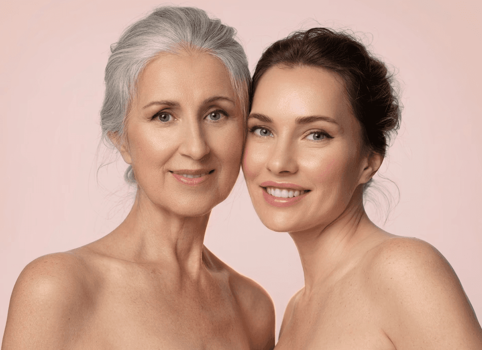 Three people laying on their backs with their heads together smiling.