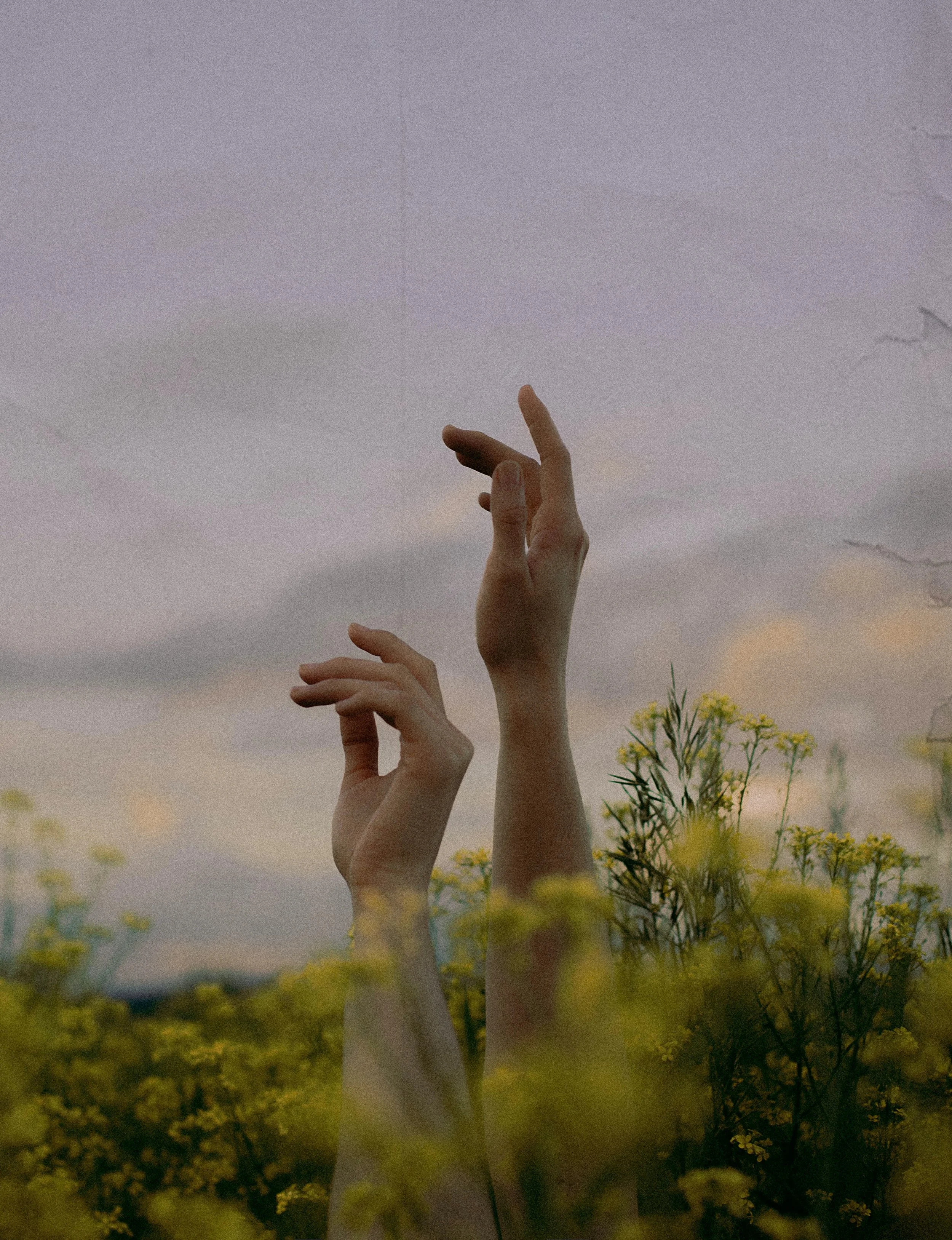 Artsy image of two hands against a sky