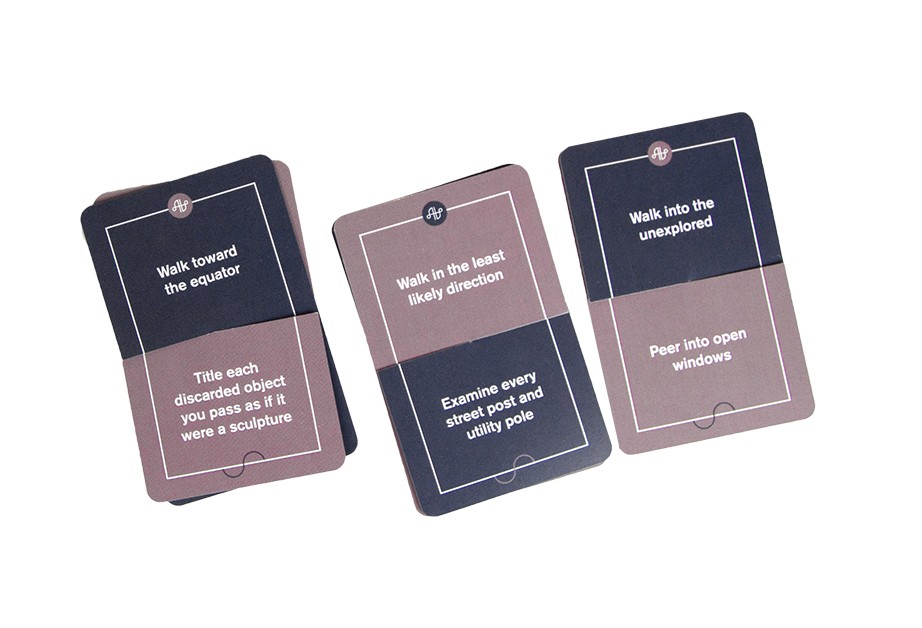 Three cards are displayed on a white background. Each card has a dark blue top section and a light brown bottom section. The text on each card reads: “Walk toward the equator,” “Walk in the least likely direction,” and “Peer into open windows.” The cards are arranged in a row.