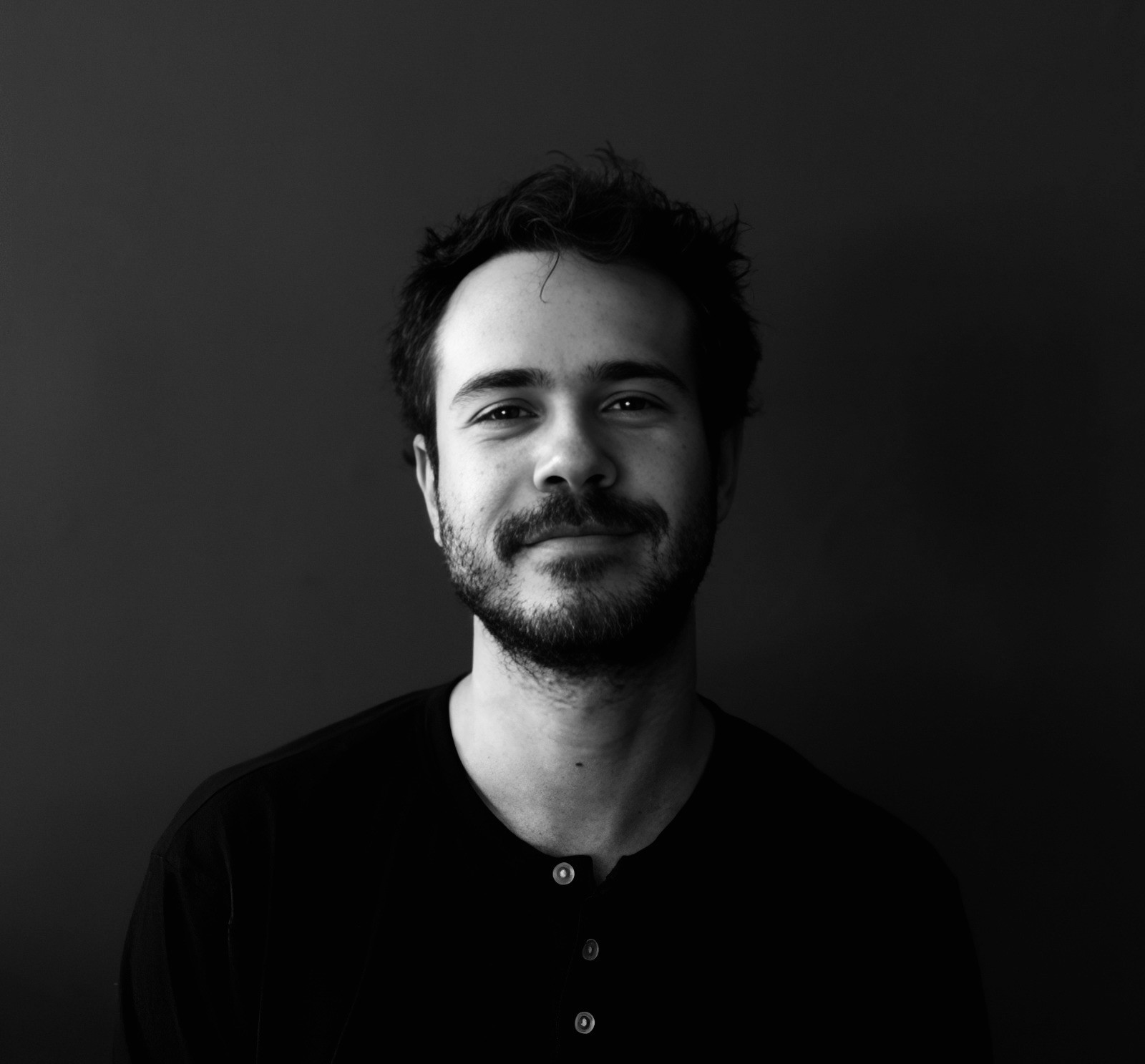 Street lamp silhouetted against building at sunset.