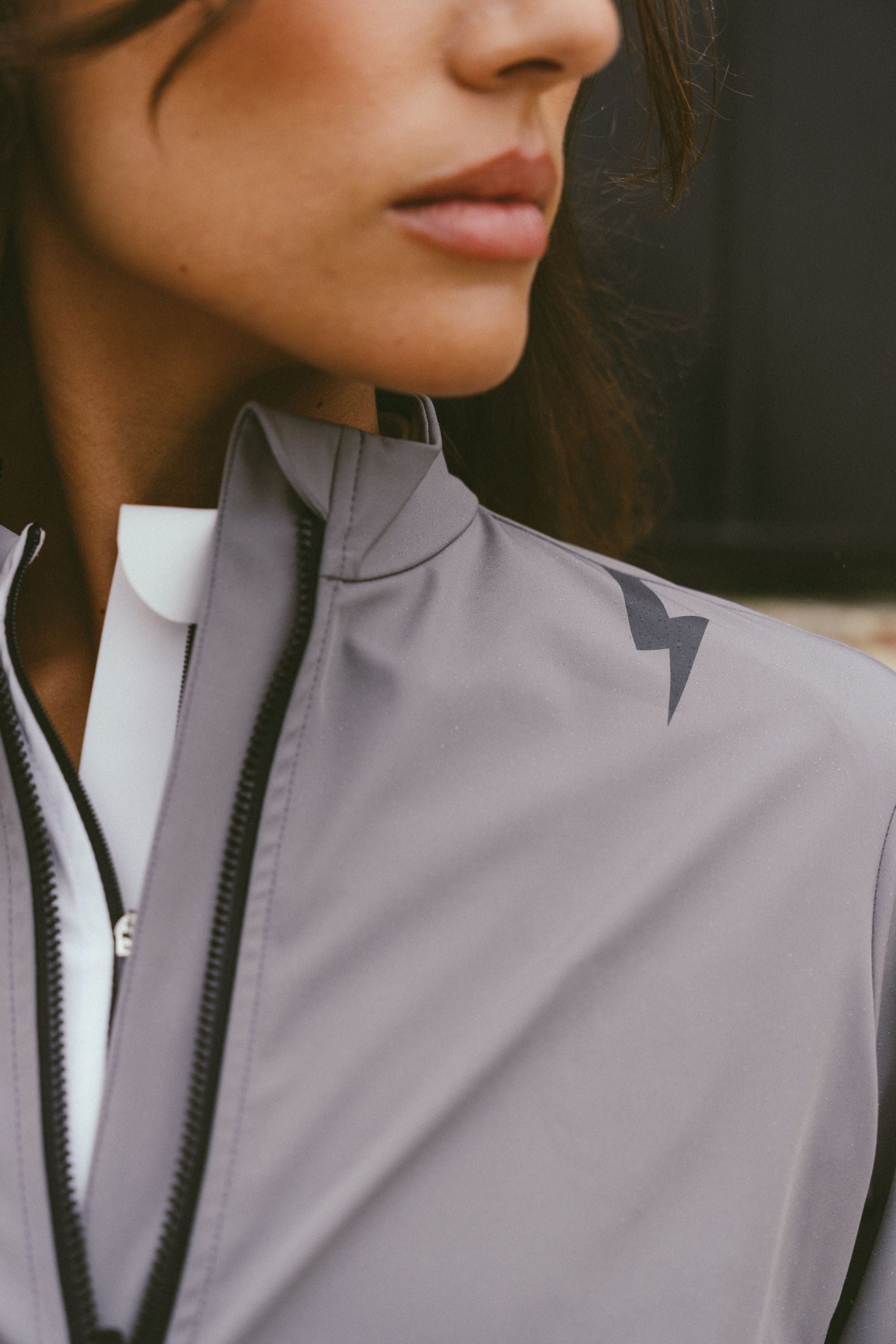 Stylish-close-up-of-the-grey-jacket-shoulder-and-collar-detail-showing-the-sporty-lighting-sign-and-clean-zippered-front