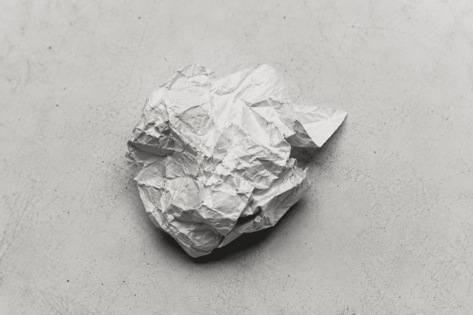 Crumpled paper on concrete surface representing the internal tension of emotional eating in ADHD
