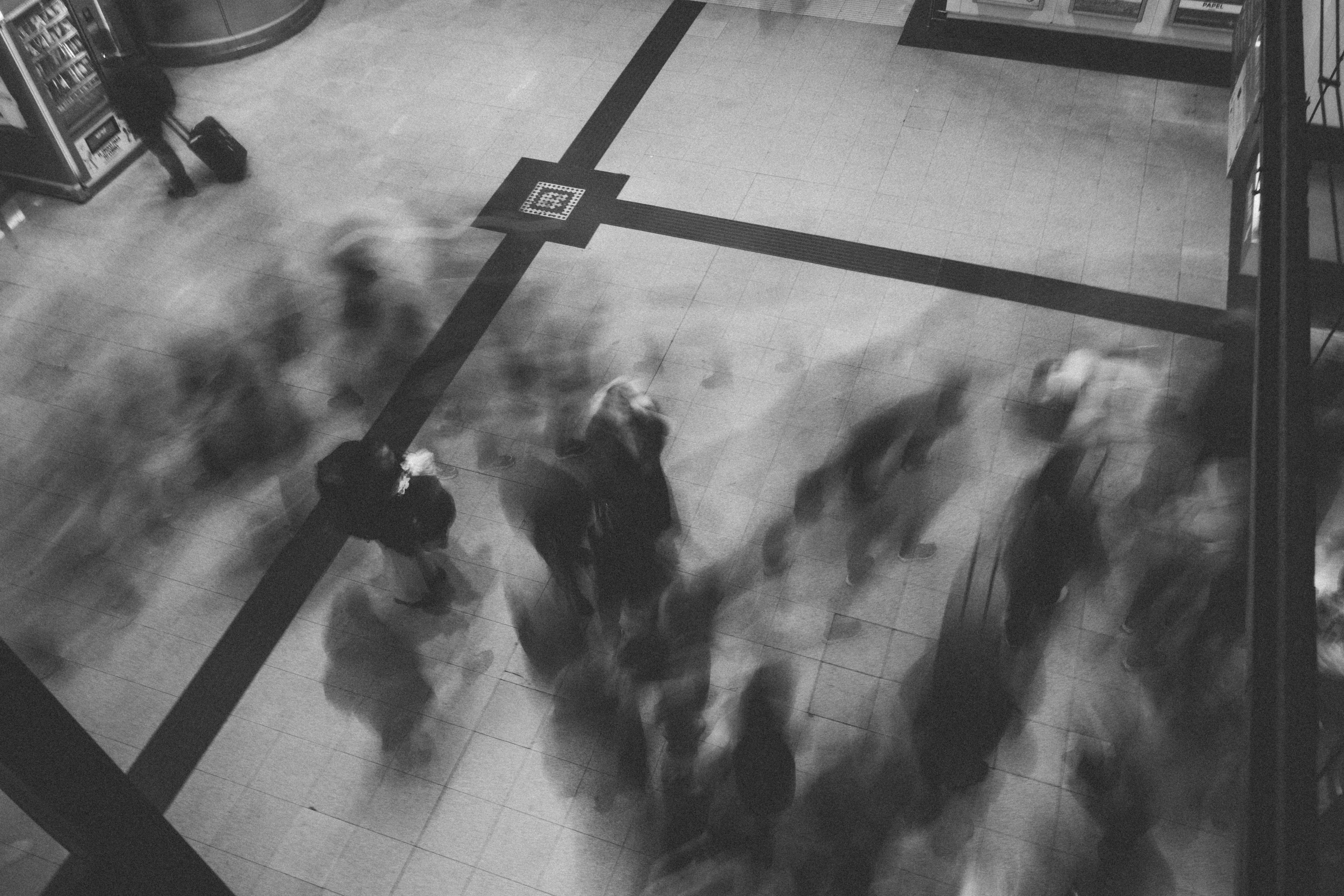 Blurred figures of people walking in a busy space