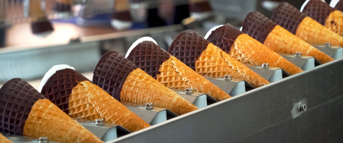 A row of ice cream cones topped with a layer of chocolate.
