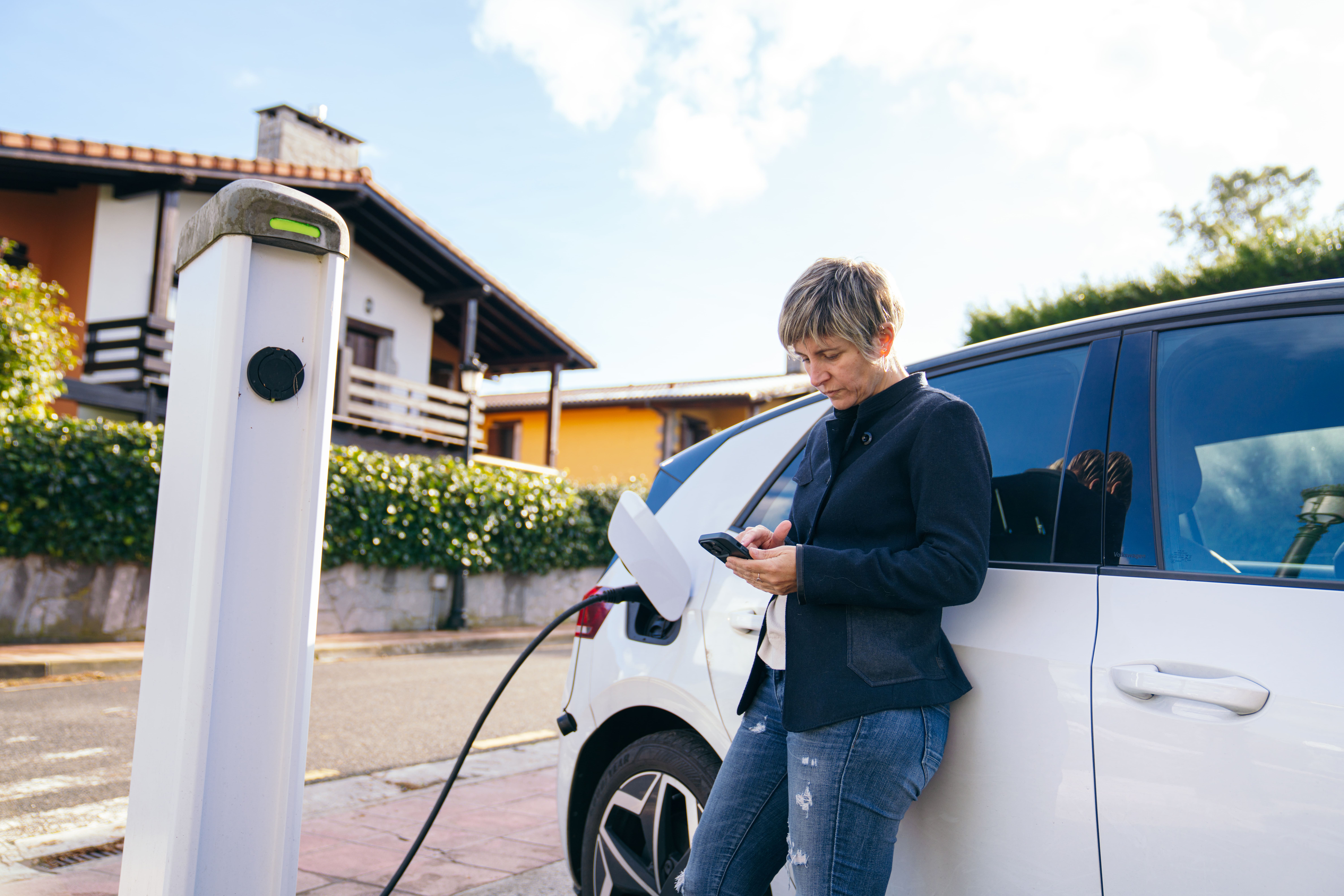 donna-appoggiata-auto-elettrica-in-carica-wallbox