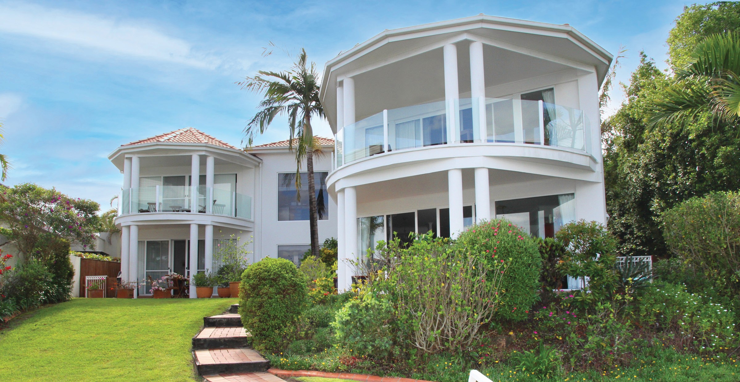Modern white houses with balconies and glass railings