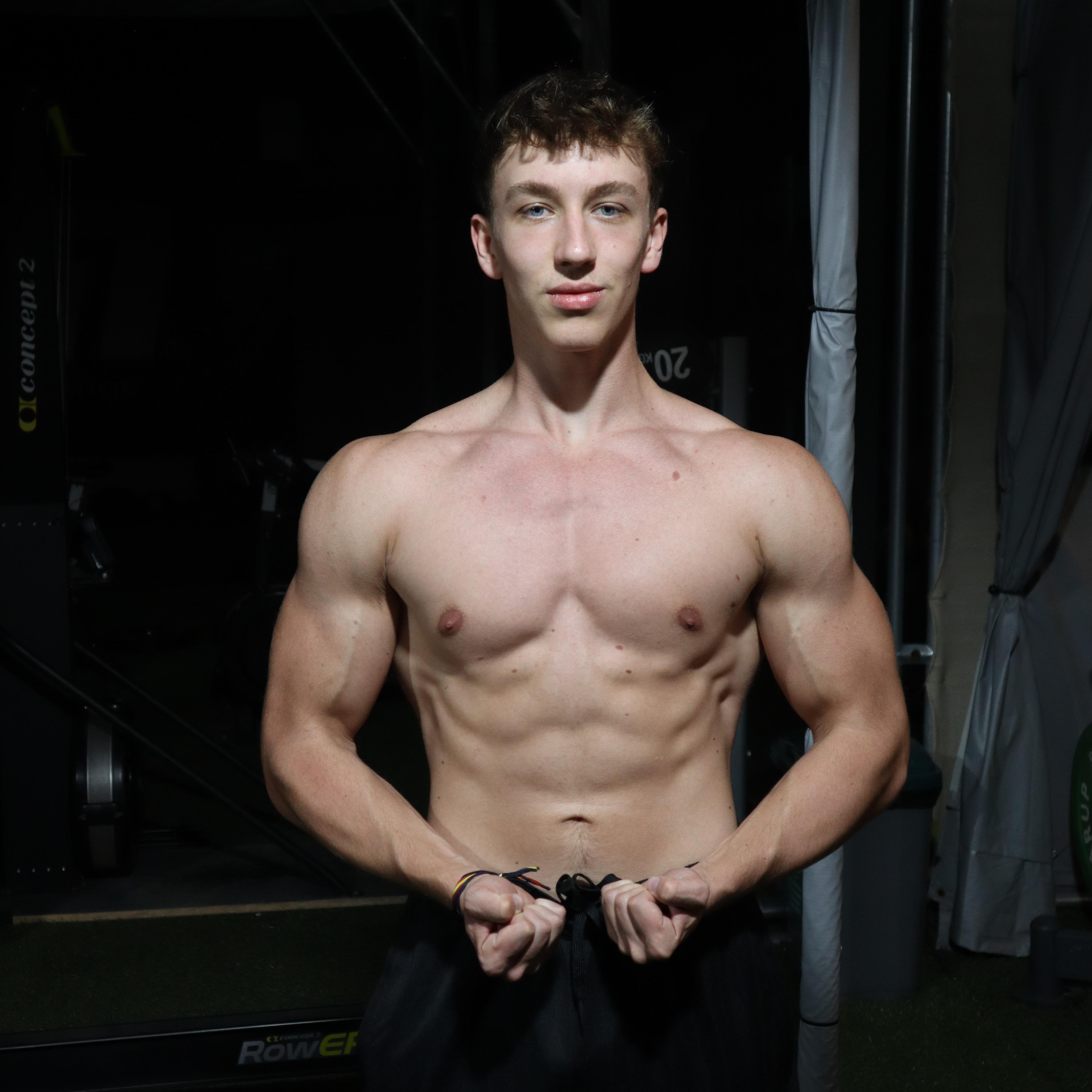 man in white tank top holding bumper plate
