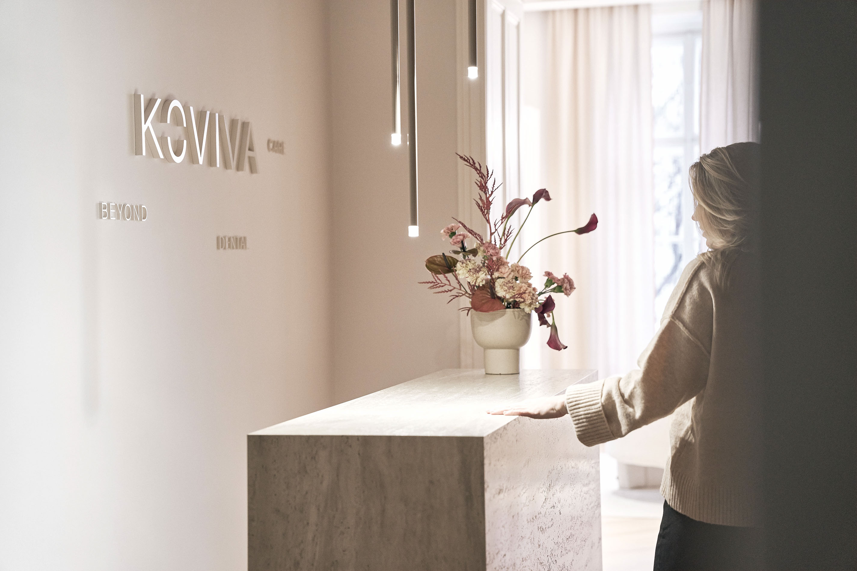 Frau und Mann lächeln sich am runden Tisch an, während sie auf ein Tablet schauen.