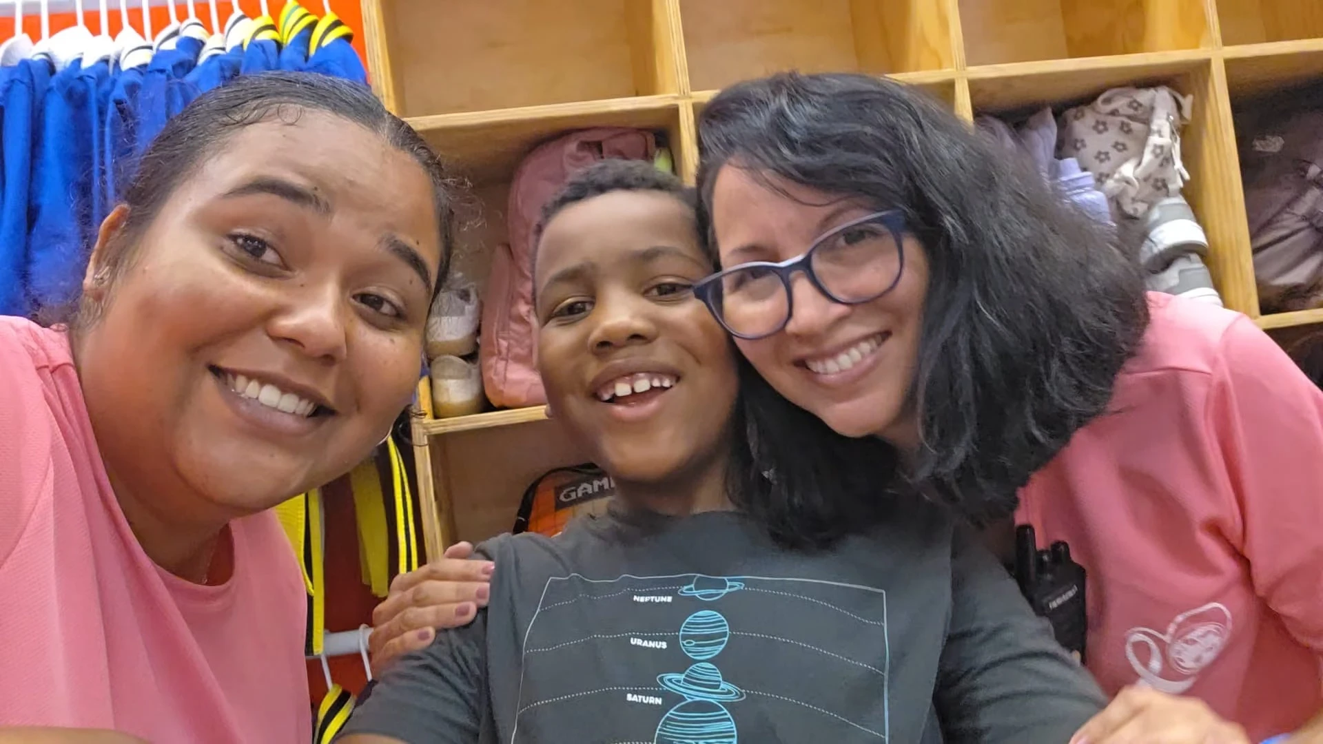 Two female team member smiling with a student.