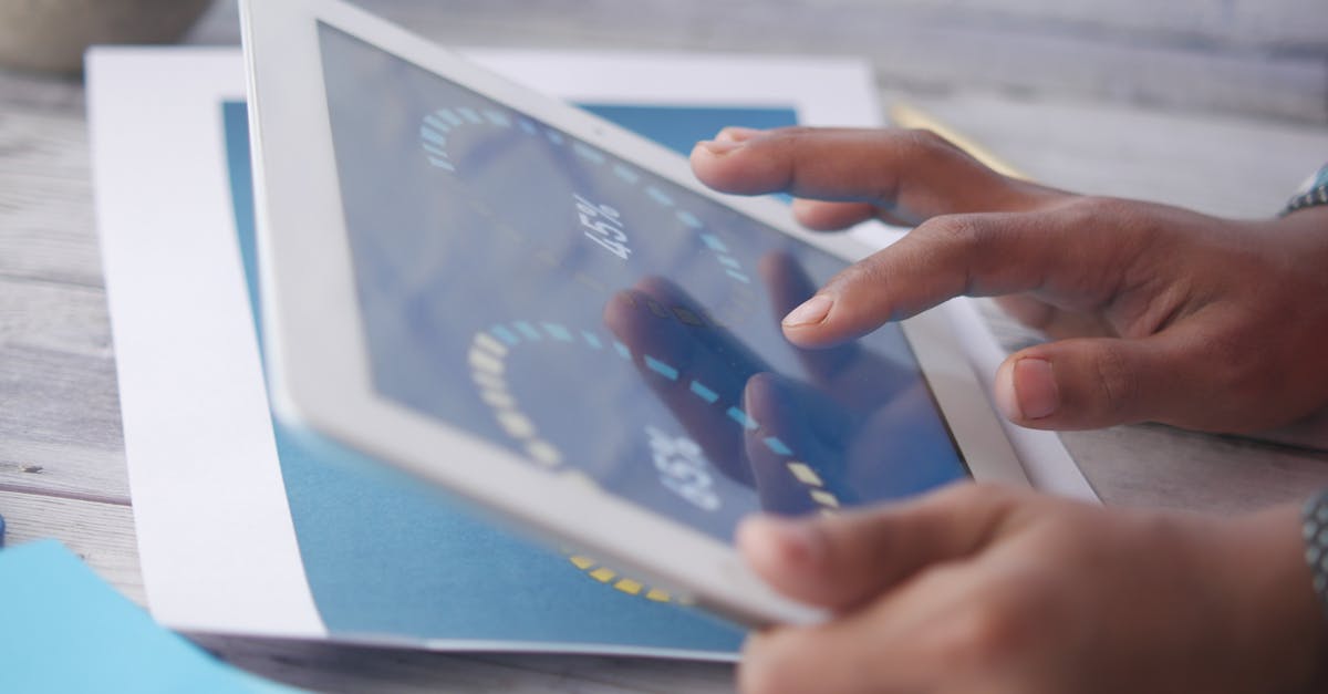 Hands interacting with a tablet, showcasing modern touchscreen technology in an indoor setting.
