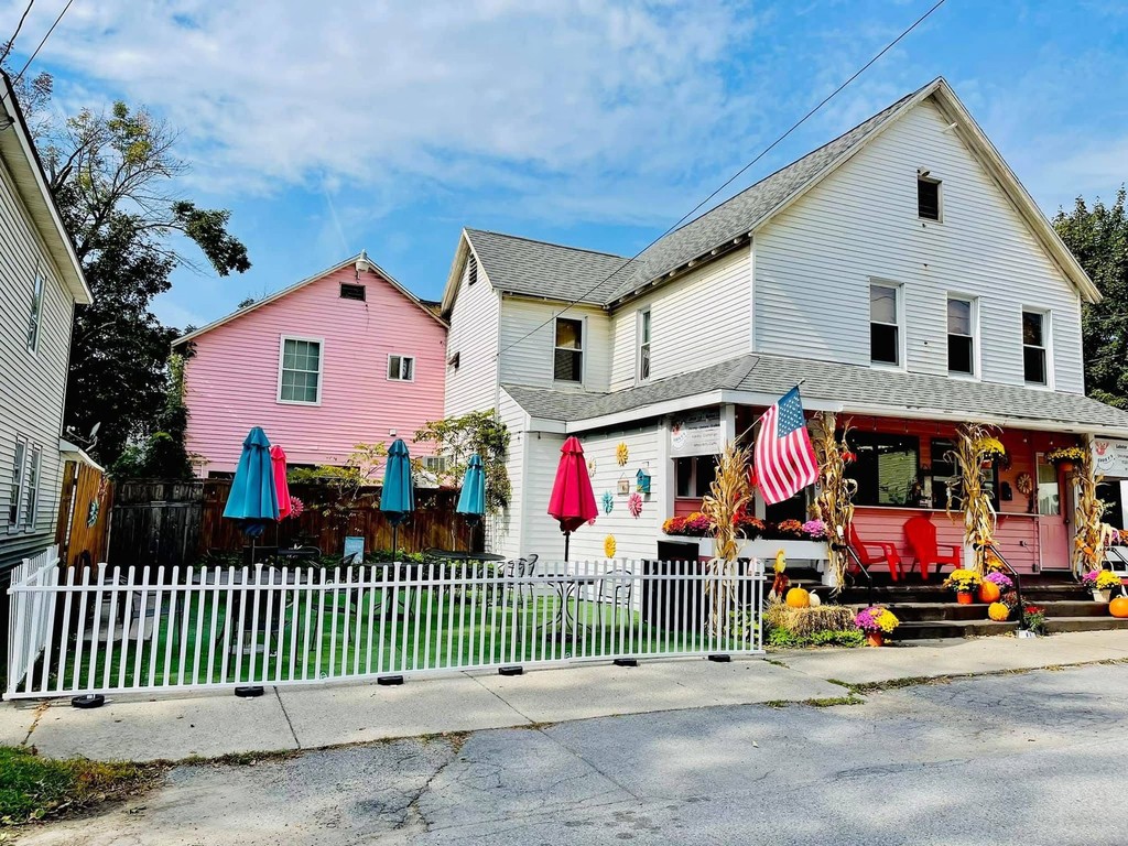 Eddie F’s Saratoga Springs from the street — the pink house, the patio umbrellas and the picket fence