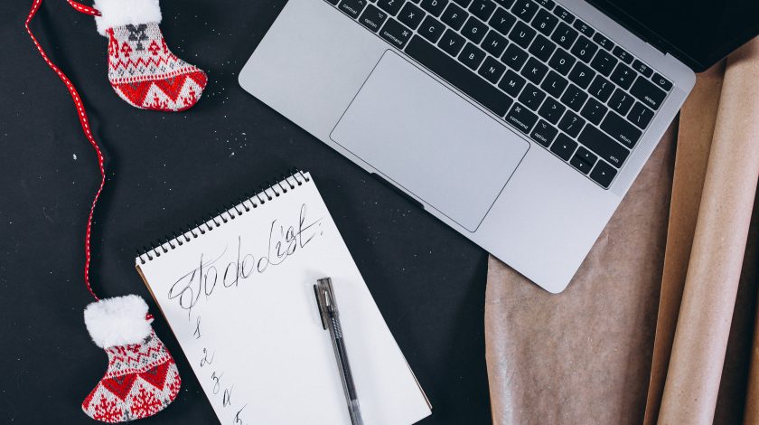 A man and a woman playing Jenga, carefully pulling out a block from a tall stack.