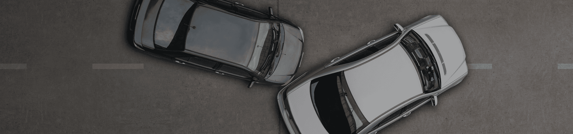 Close-up photograph of front-end vehicle damage after a collision