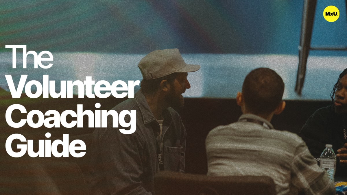 Cover image for the free MxU worship resource 'The Volunteer Coaching Guide': three people talk at a table, title in bold, yellow MxU logo top right.