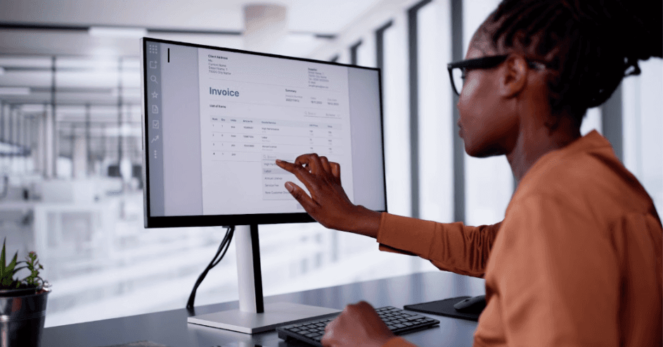 Iemand wijst naar een computerscherm terwijl ze zakelijke financiële beslissingen maken op kantoor.