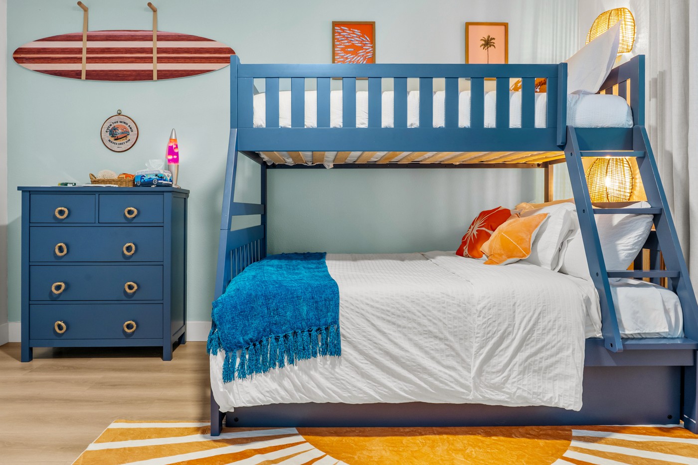 Colorful surf-themed bunk bedroom with blue built-in beds and coastal wall decor in an Anna Maria Island vacation rental