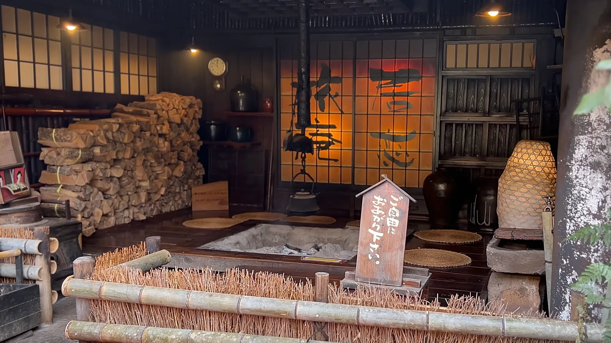 An irori room at a Kurokawa Onsen inn with stacked firewood and warmly lit shoji screens