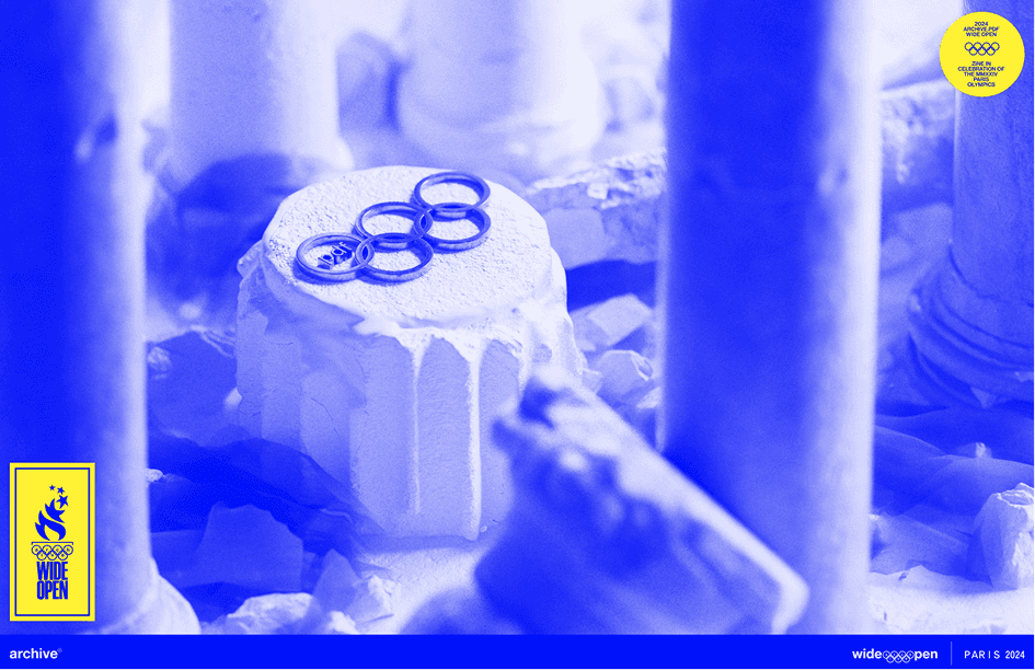 Archive PDF wide open Paris 2024 editorial cover image showing a white cake topped with Olympic style rings in a blue duotone colorway with the wide open Paris 2024 branding and yellow badge