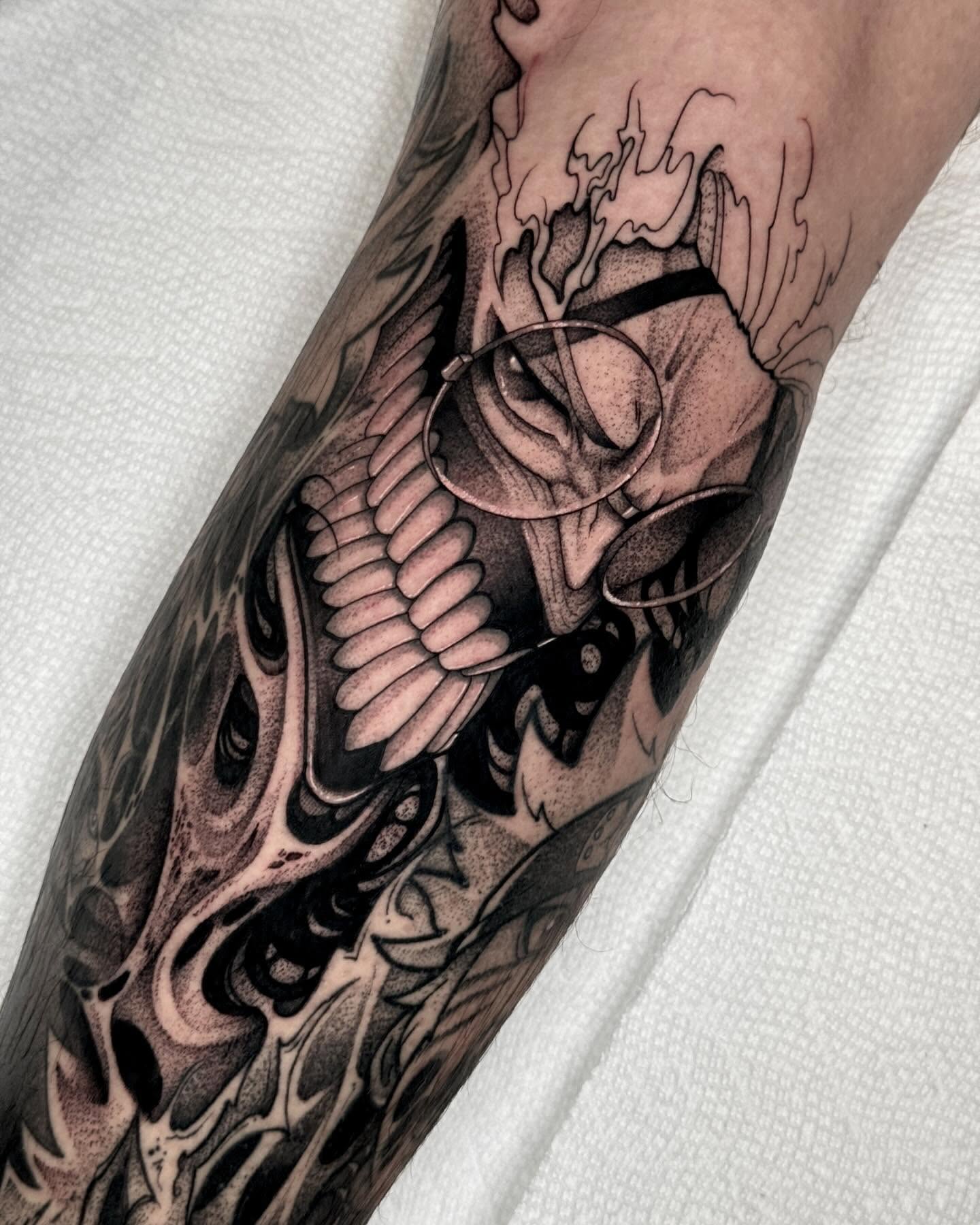 In this stunning blackwork tattoo by XQ Ink, Okarun's intense transformation is depicted with dramatic contrast and intricate linework. The angular jawline, clenched teeth, and glowing glasses radiate a sense of chaos and power, while the surrounding smoky patterns add depth to the piece. This design captures the tension and supernatural energy that defines Okarun's character arc, making it an impressive choice for fans of the series.