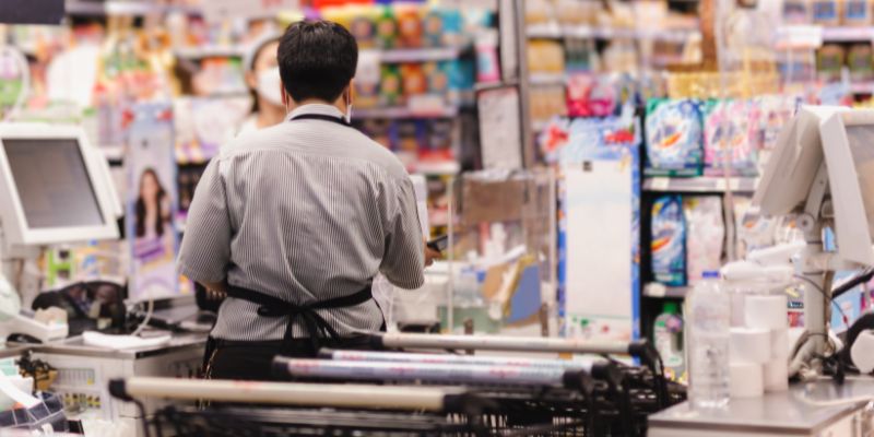 Pekerja kedai runcit melayan pelanggan