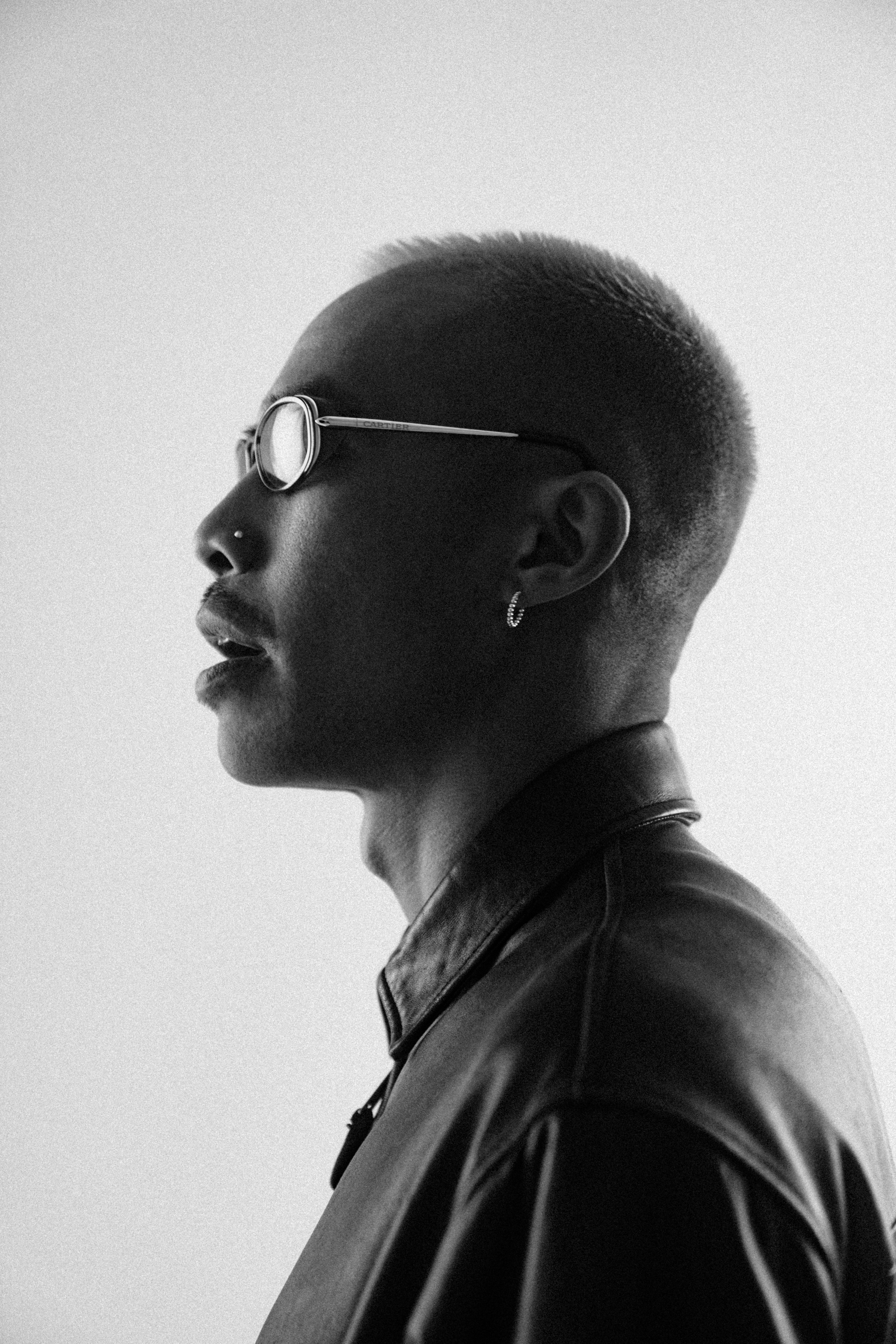 Man with short hair and glasses in profile.