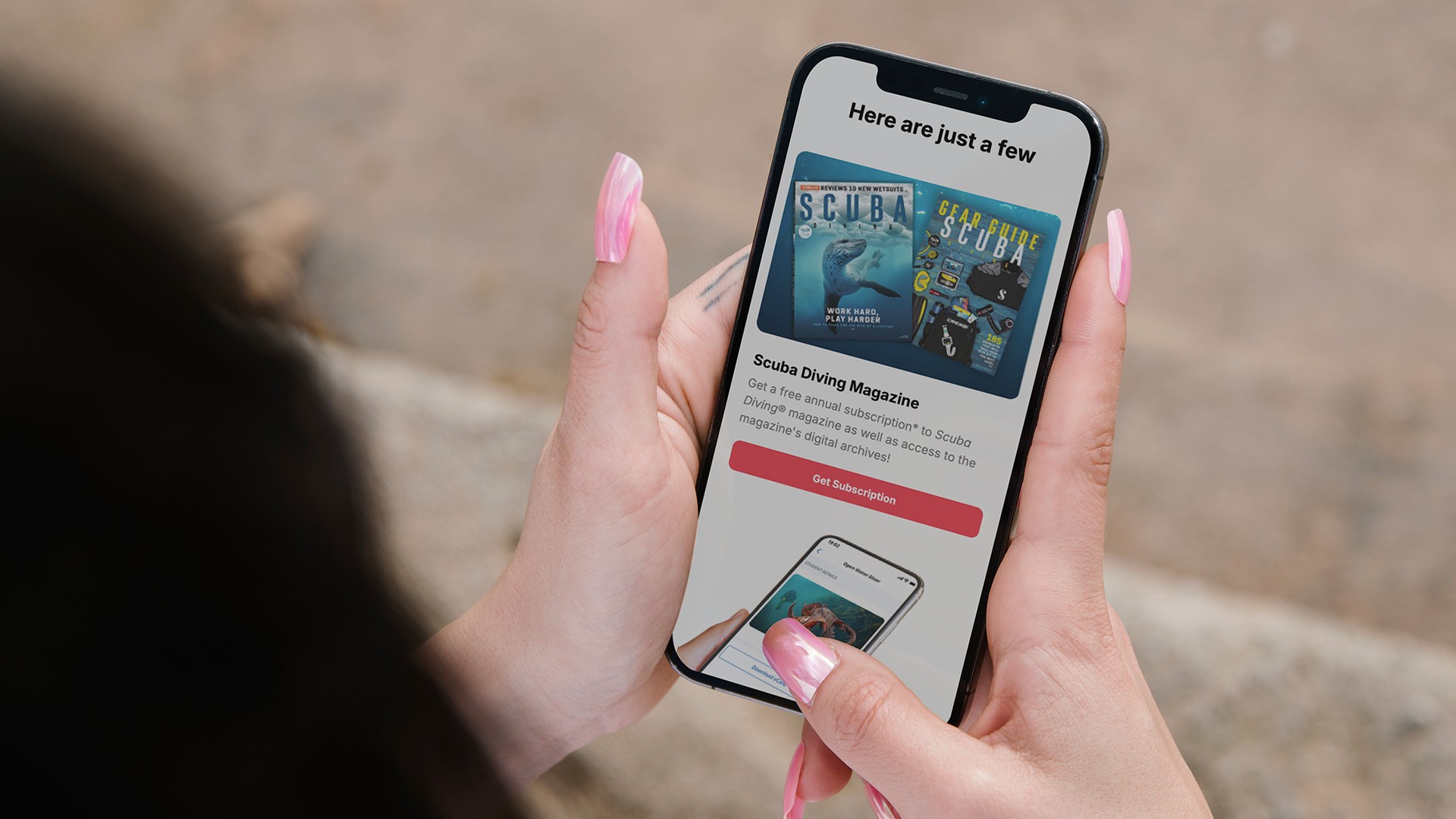 Person holding a smartphone displaying a PADI Club email experience featuring magazine content, membership benefits, and mobile-first promotional modules designed within PADI’s branded email system.