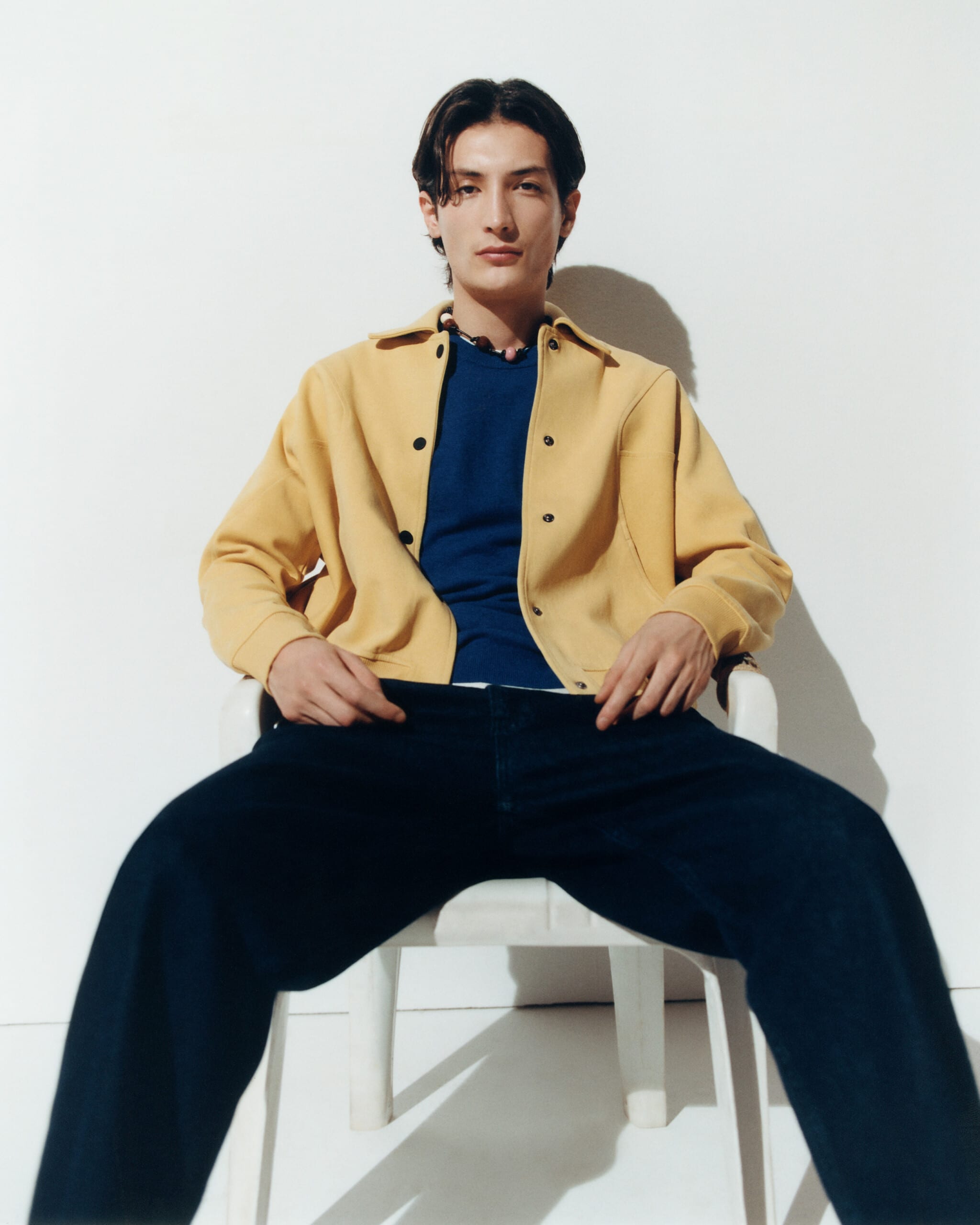 Un mannequin homme porte une veste jaune et un pantalon noir