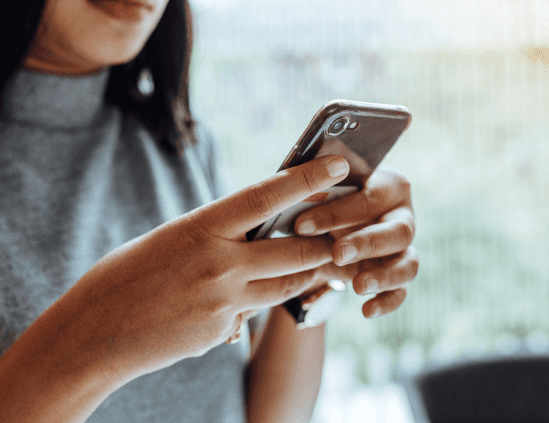 Two men reviewing documents together by a large window, with sunlight streaming in.