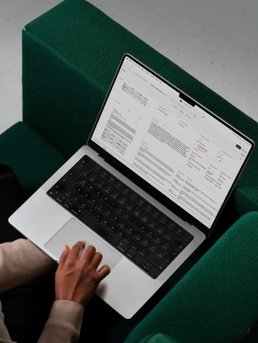Laptop with documents open on screen, hand on touchpad