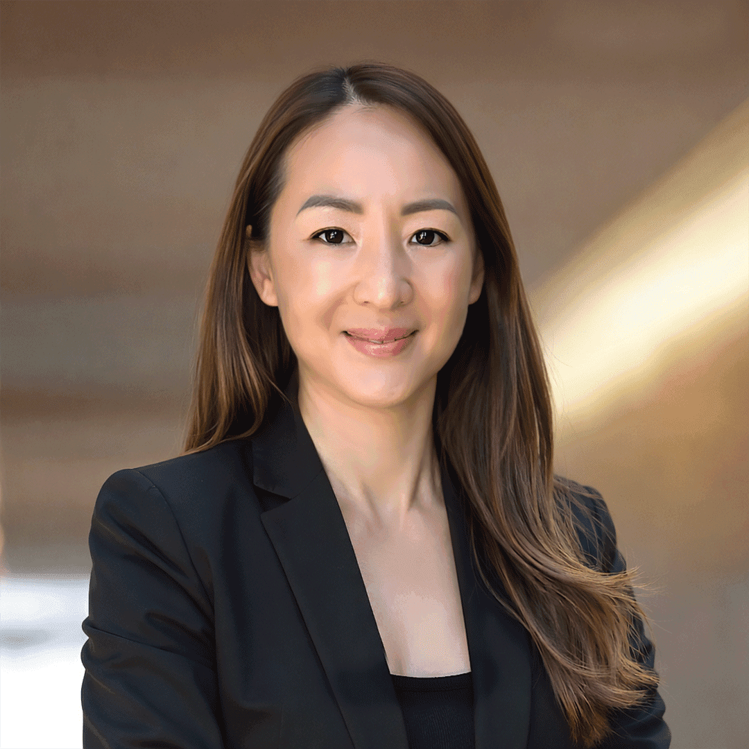 Silhouette of a researcher examining a slide under a microscope with a blue background.