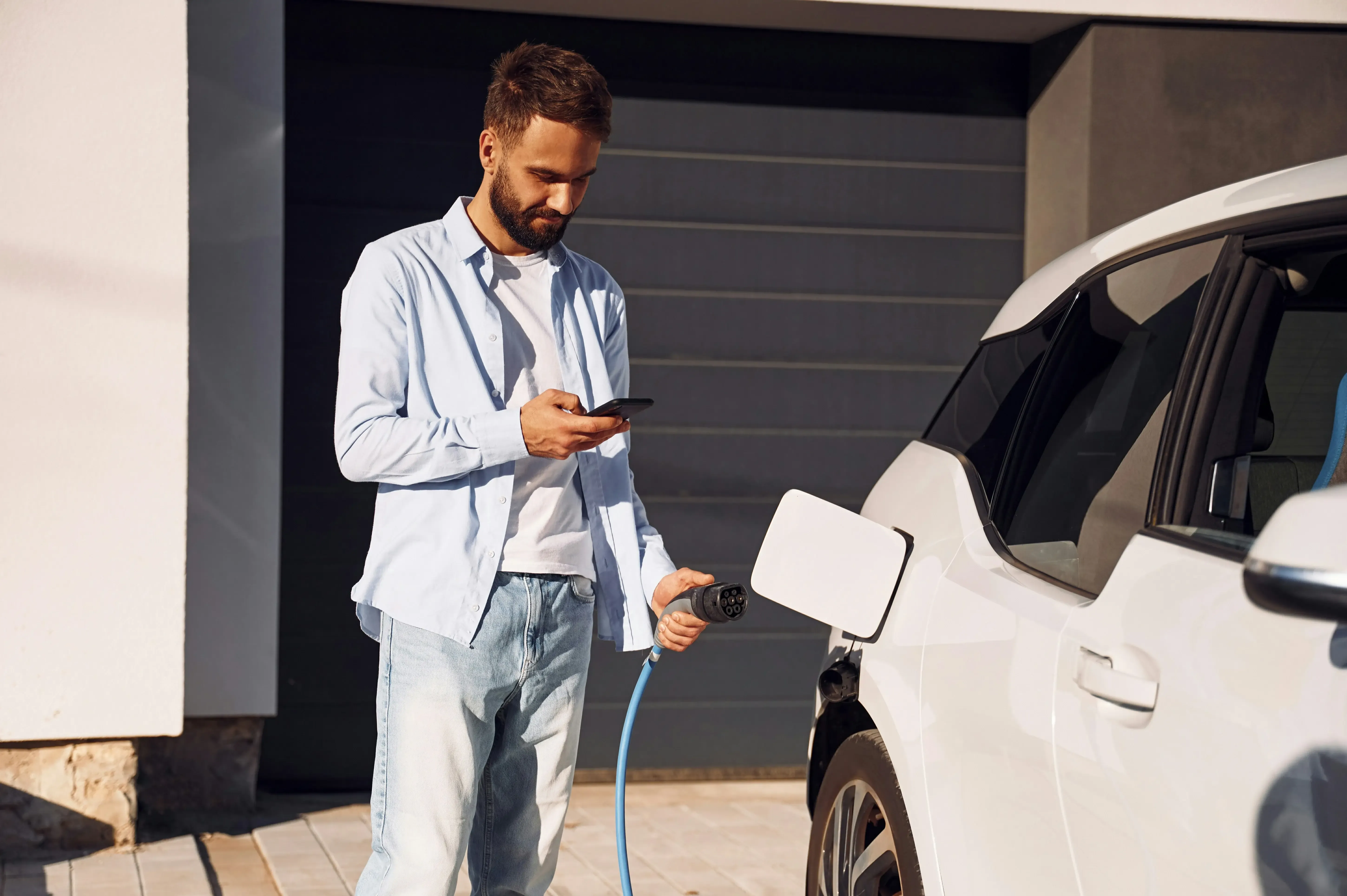 homme qui recharge son véhicule électrique