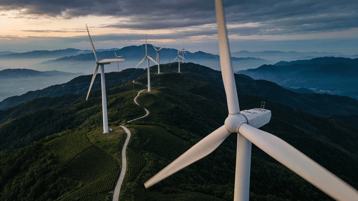 white wind turbine under blue sky during daytime